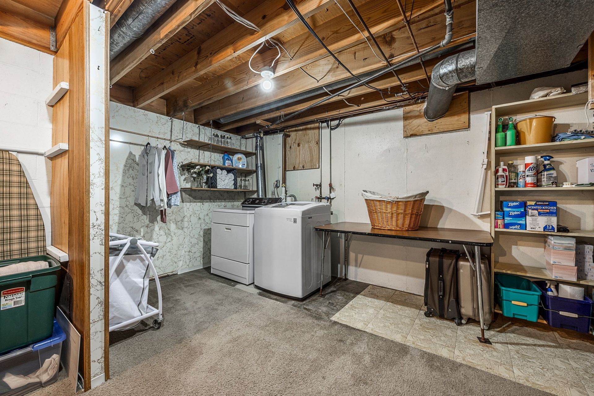 A laundry room in a basement with a washer and dryer.