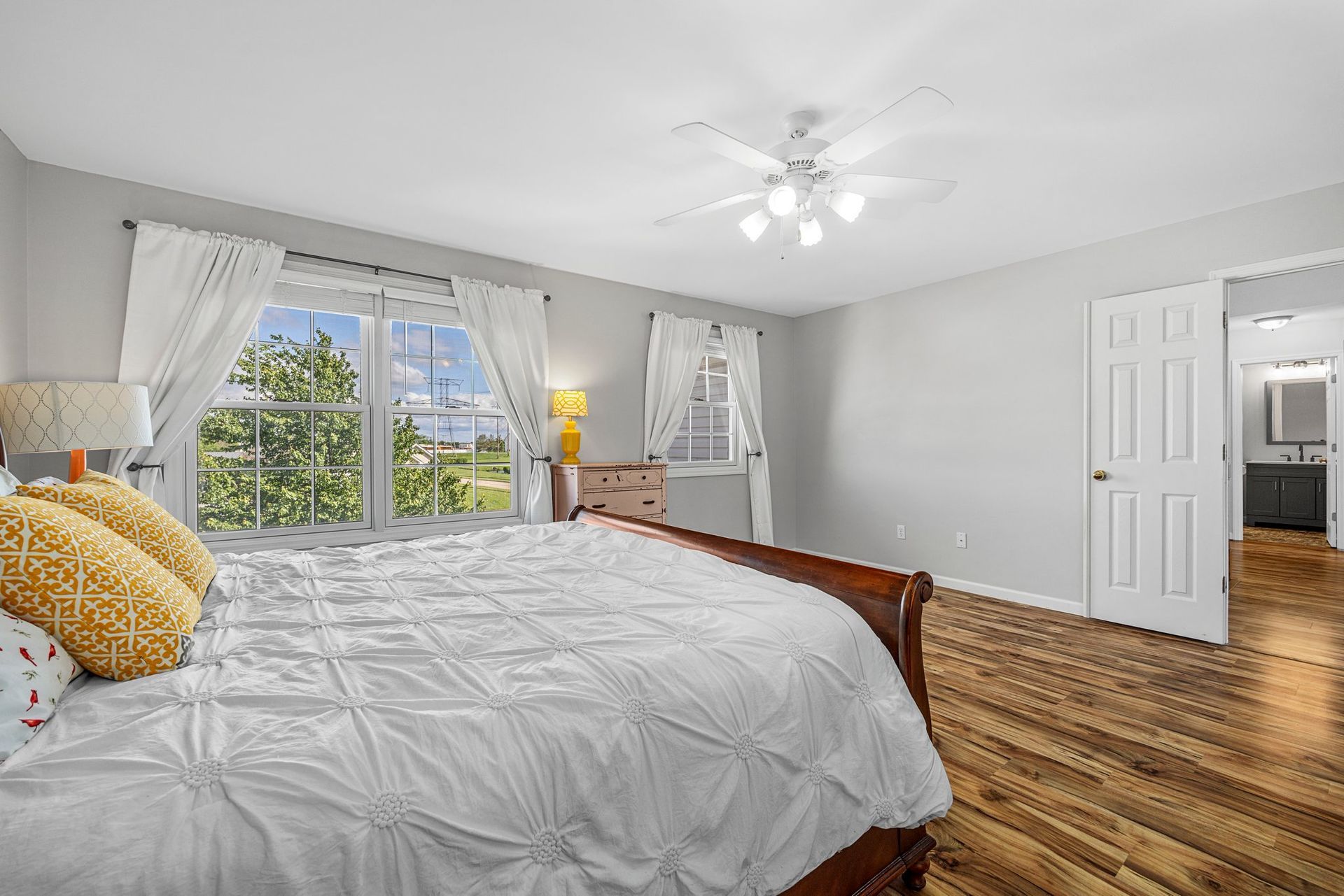 A bedroom with a king size bed and a ceiling fan.