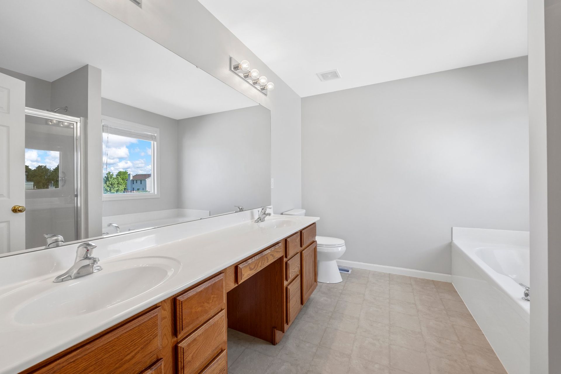 A bathroom with two sinks , a toilet , and a bathtub.