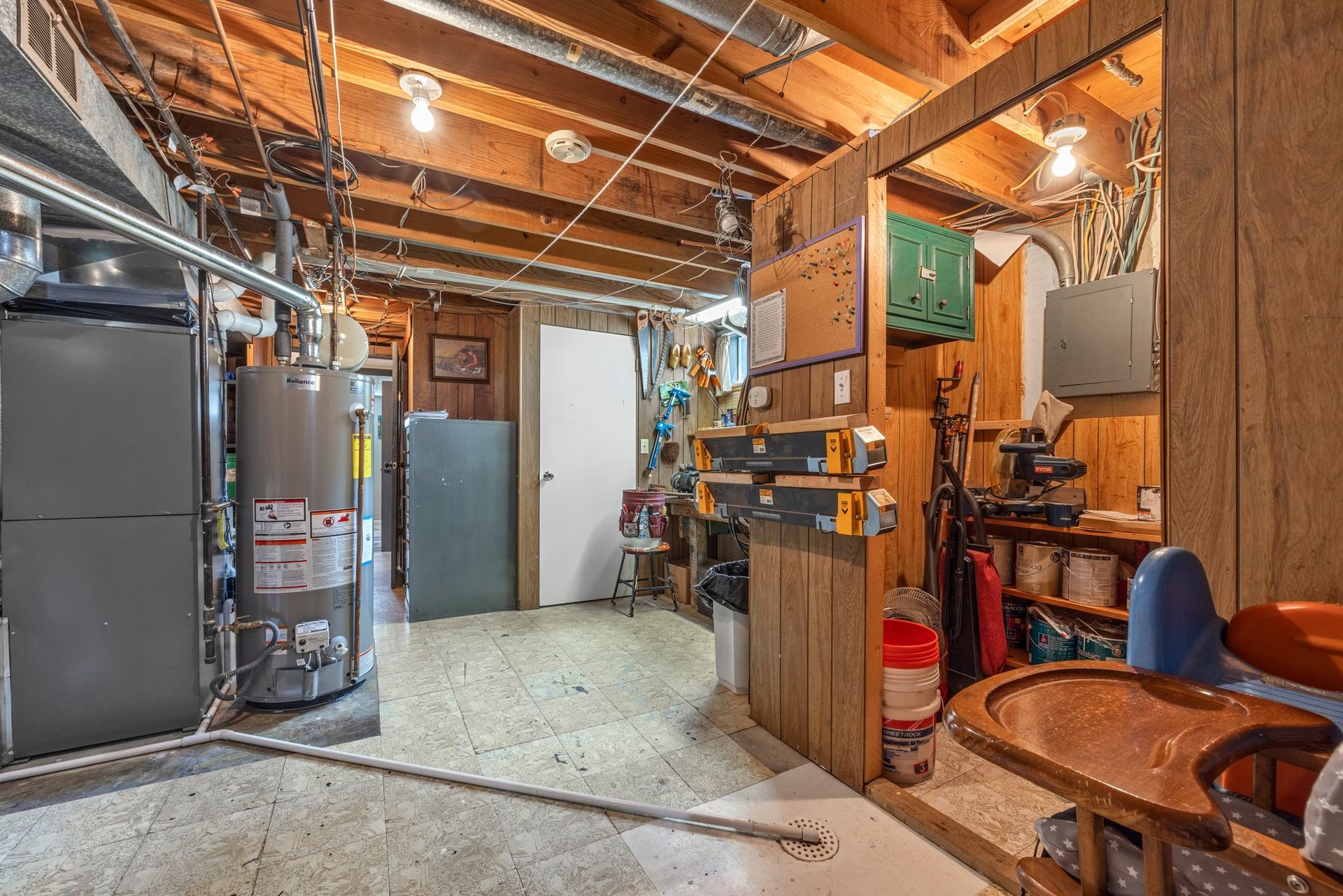 A basement with a water heater and a table.