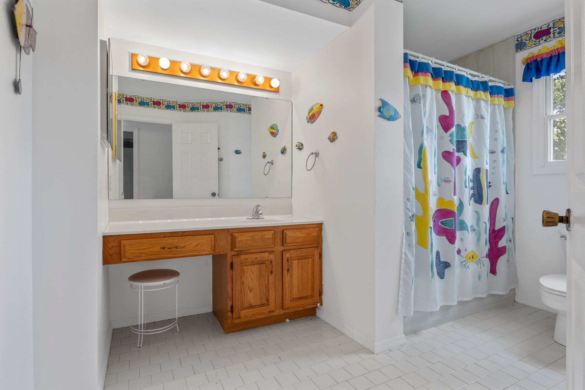 A bathroom with a sink , mirror , shower curtain and toilet.