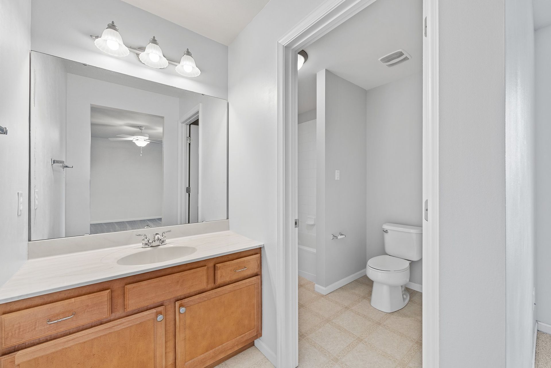 A bathroom with a sink , toilet and mirror.