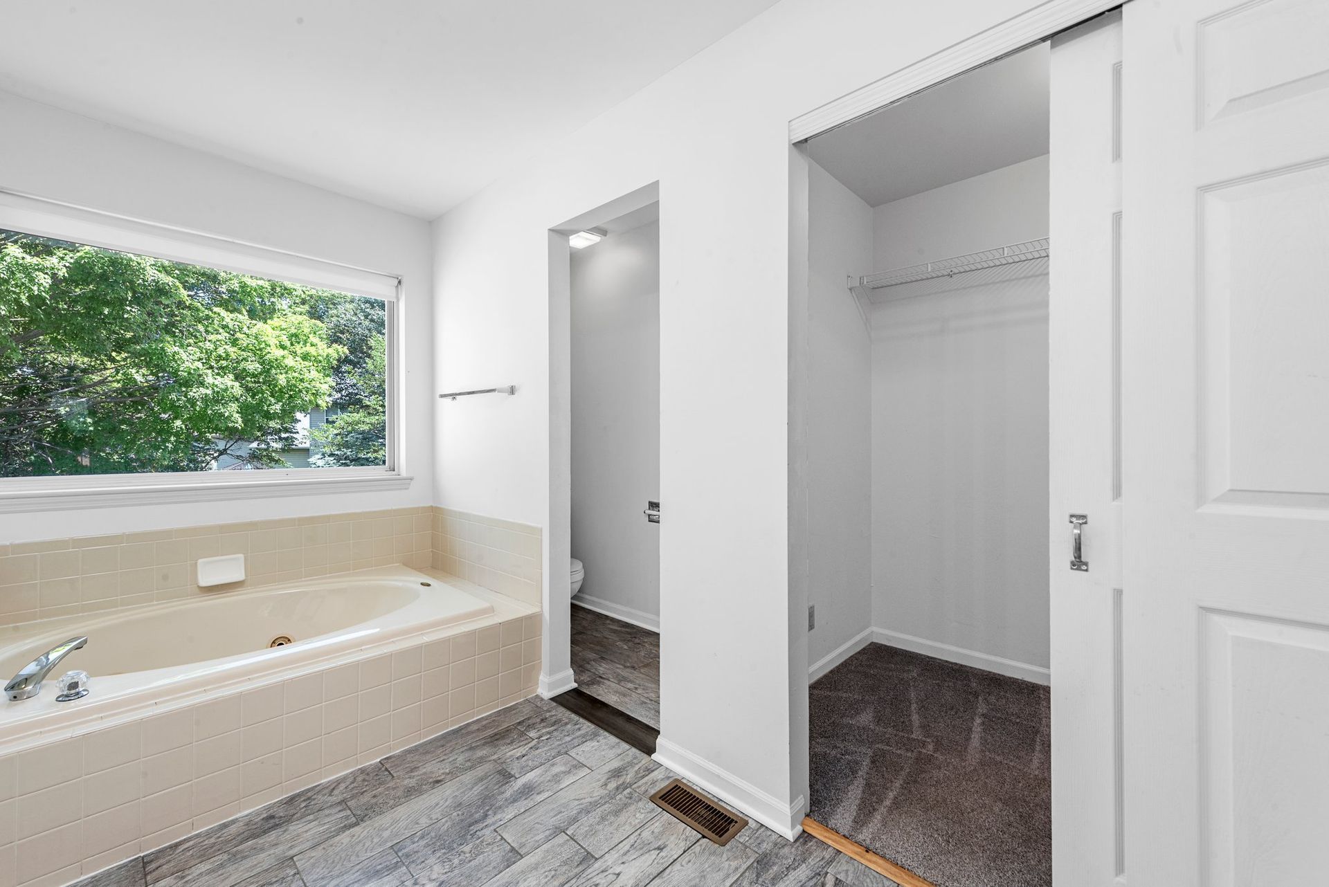 A bathroom with a bathtub and a window.