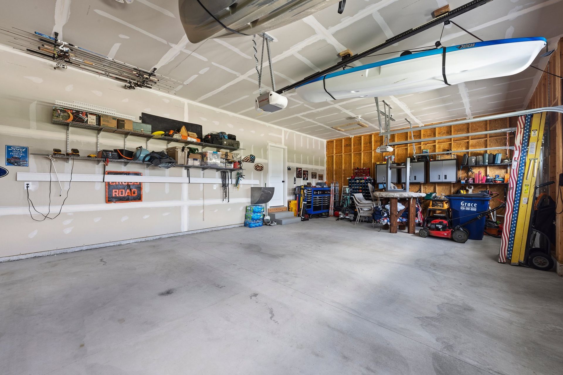 An empty garage with a surfboard hanging from the ceiling.