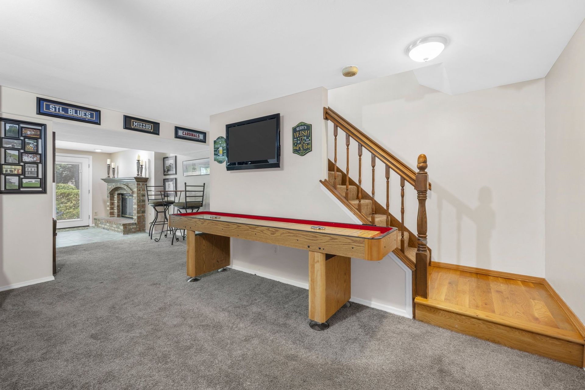 A basement with a pool table and stairs leading up to the second floor.