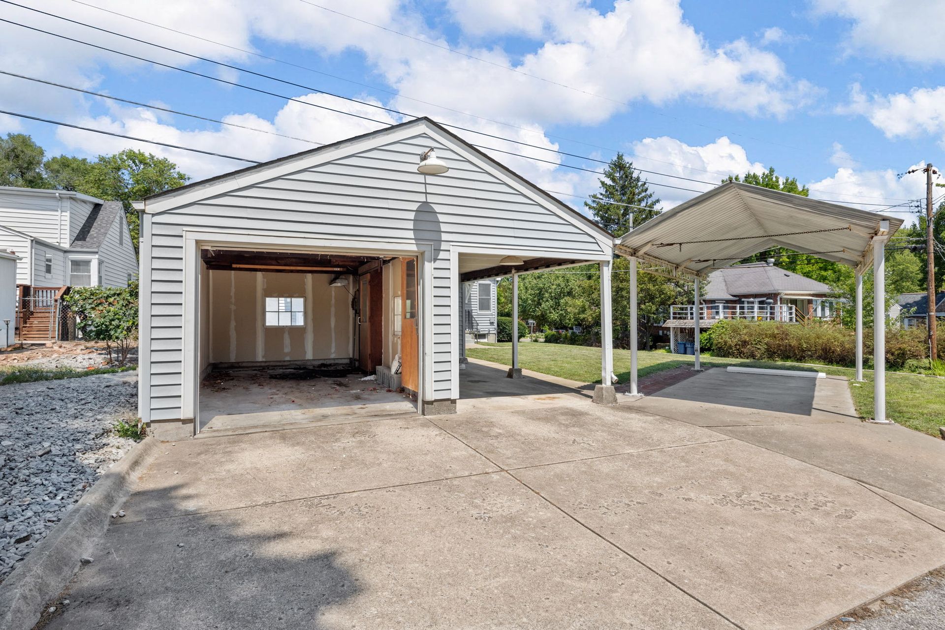A white garage with a carport attached to it
