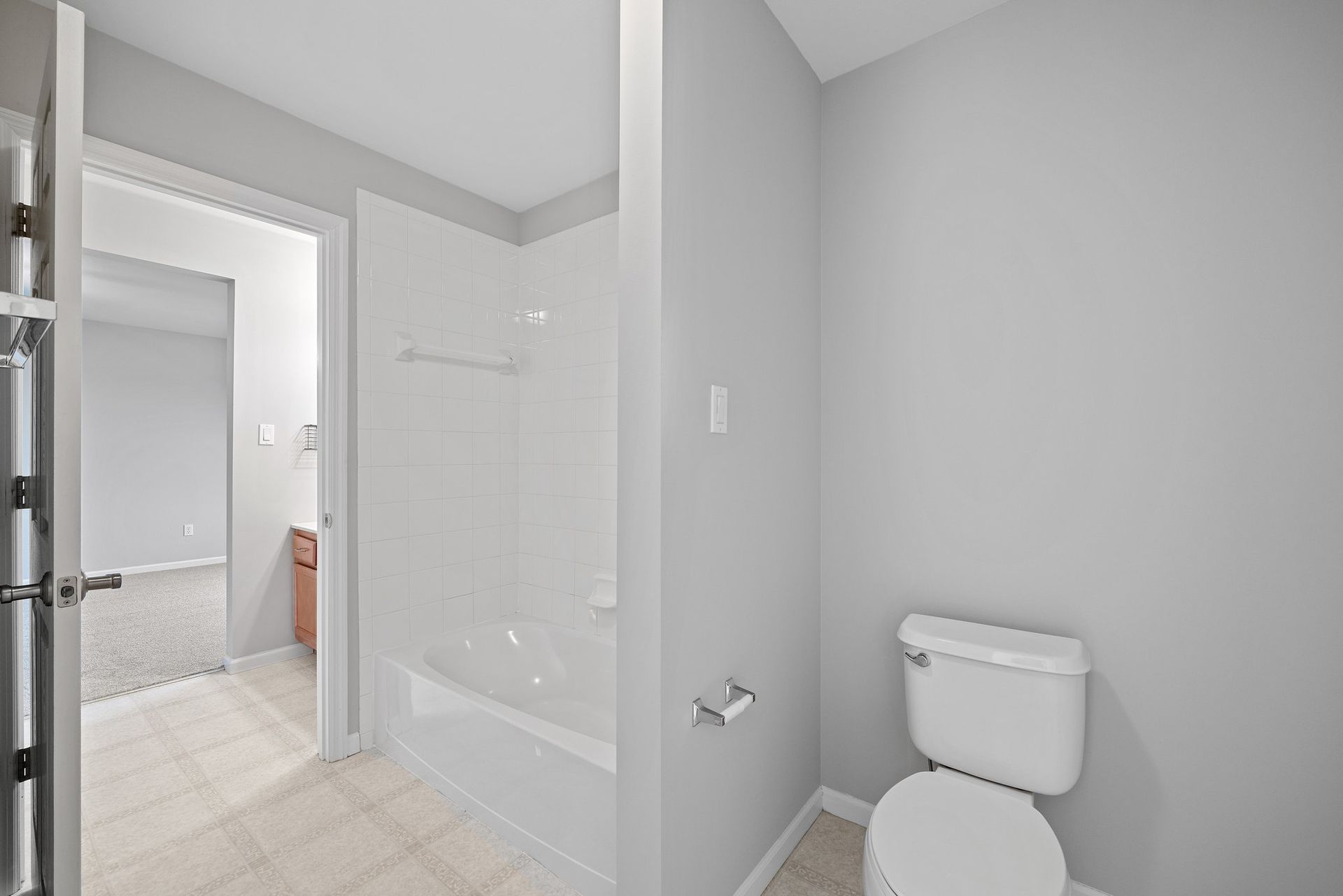 A bathroom with a toilet , bathtub and shower.