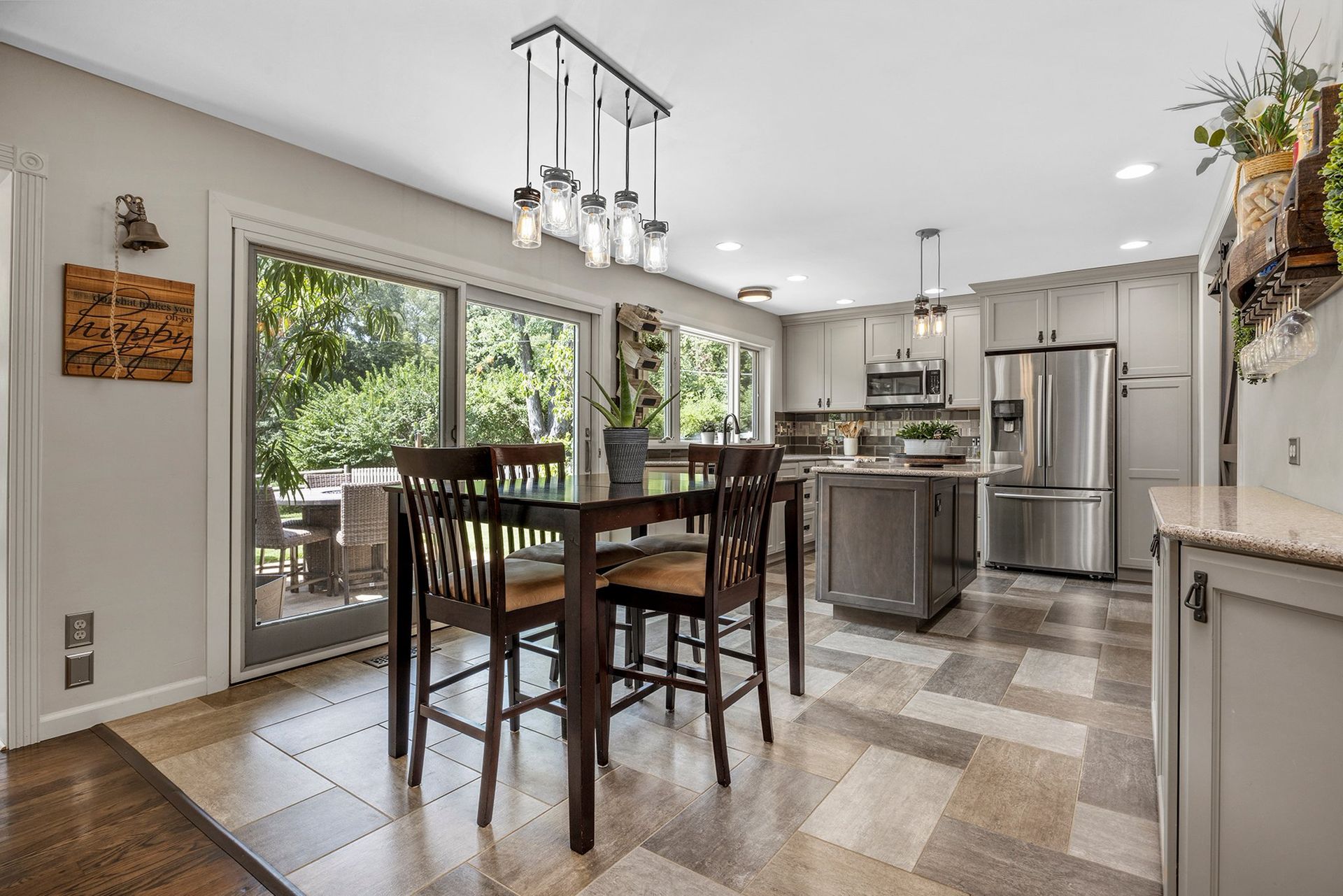 A dining room table and chairs in a kitchen with sliding glass doors.