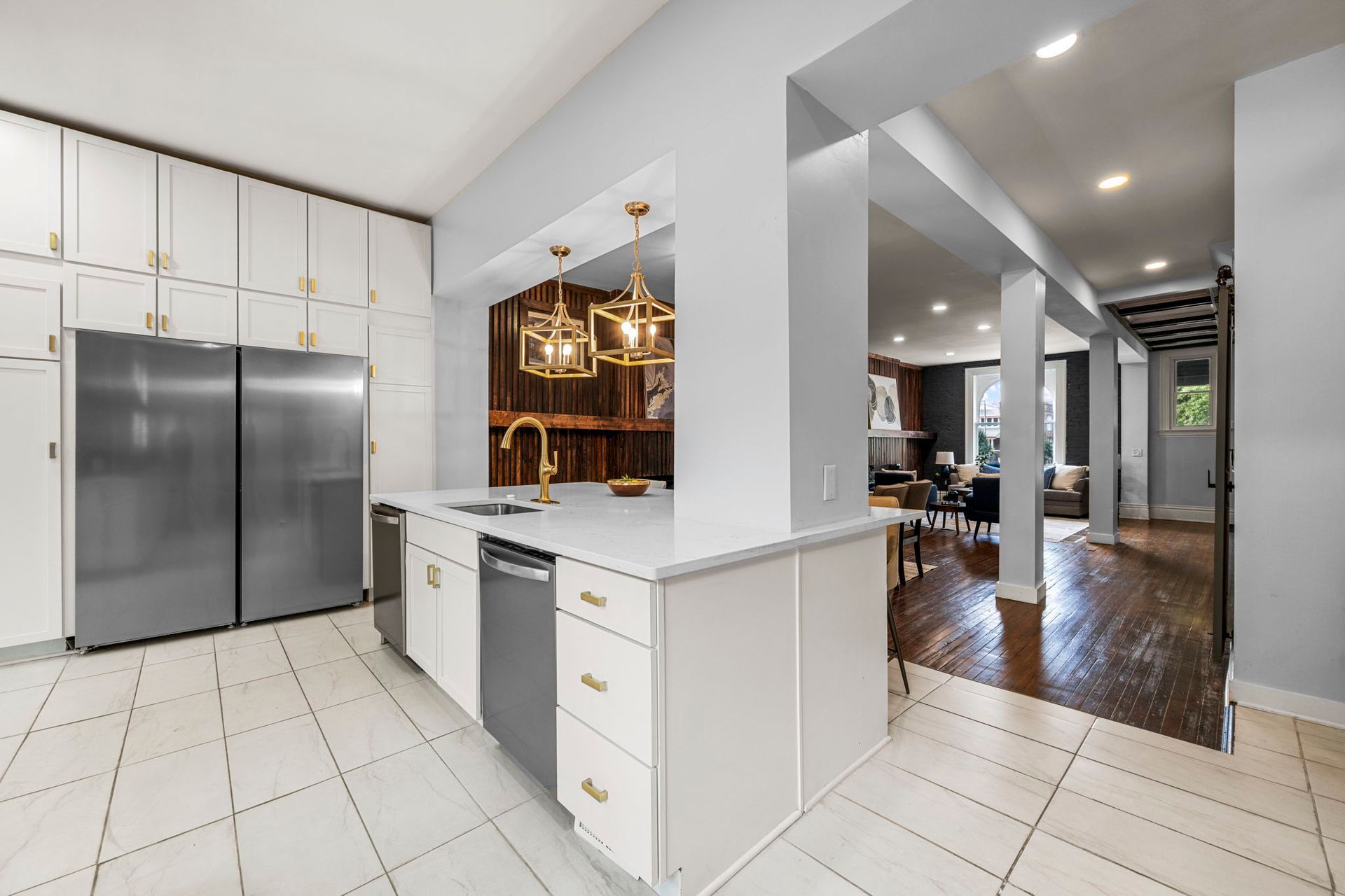 Modern kitchen with white cabinetry, stainless steel appliances, and a view into the living room.