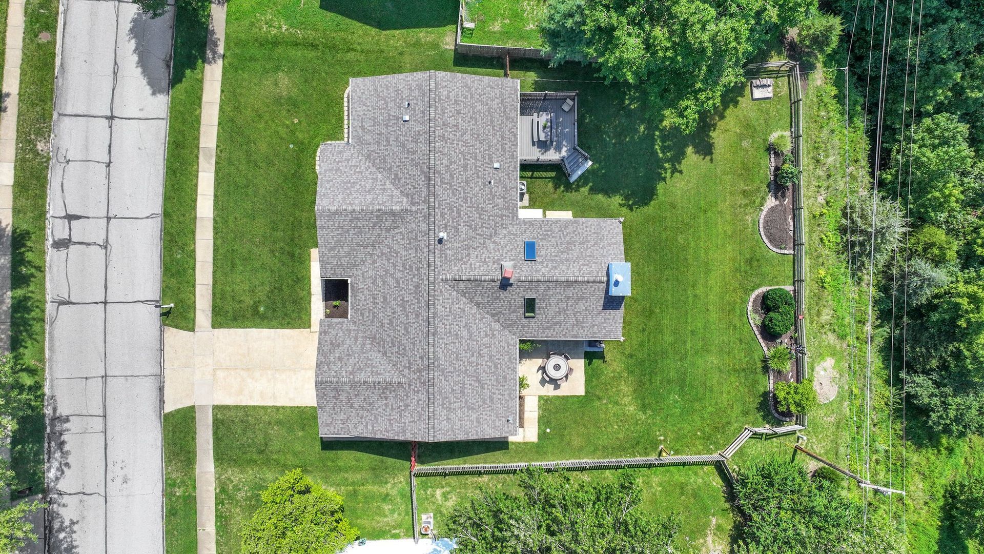An aerial view of a house with a lot of grass and trees.