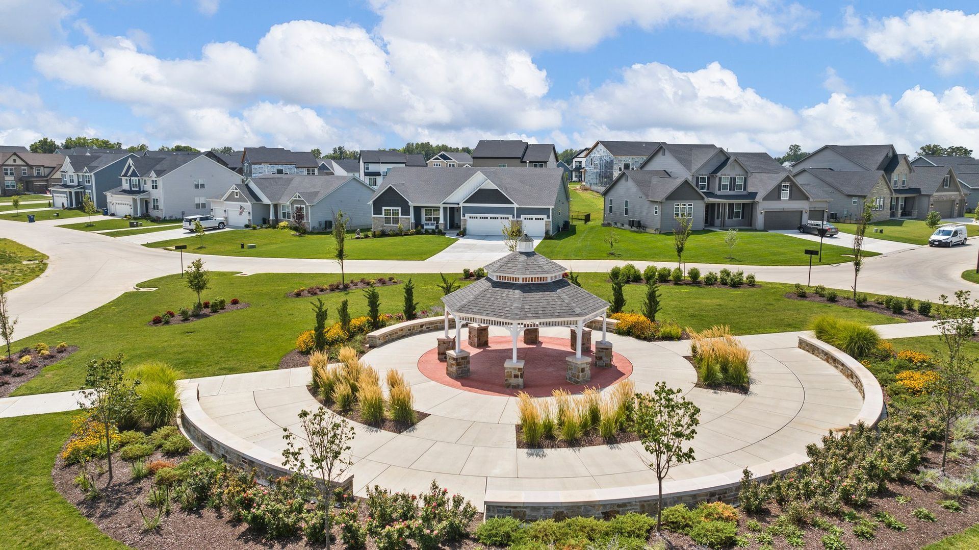 An aerial view of a residential neighborhood with a gazebo in the middle.