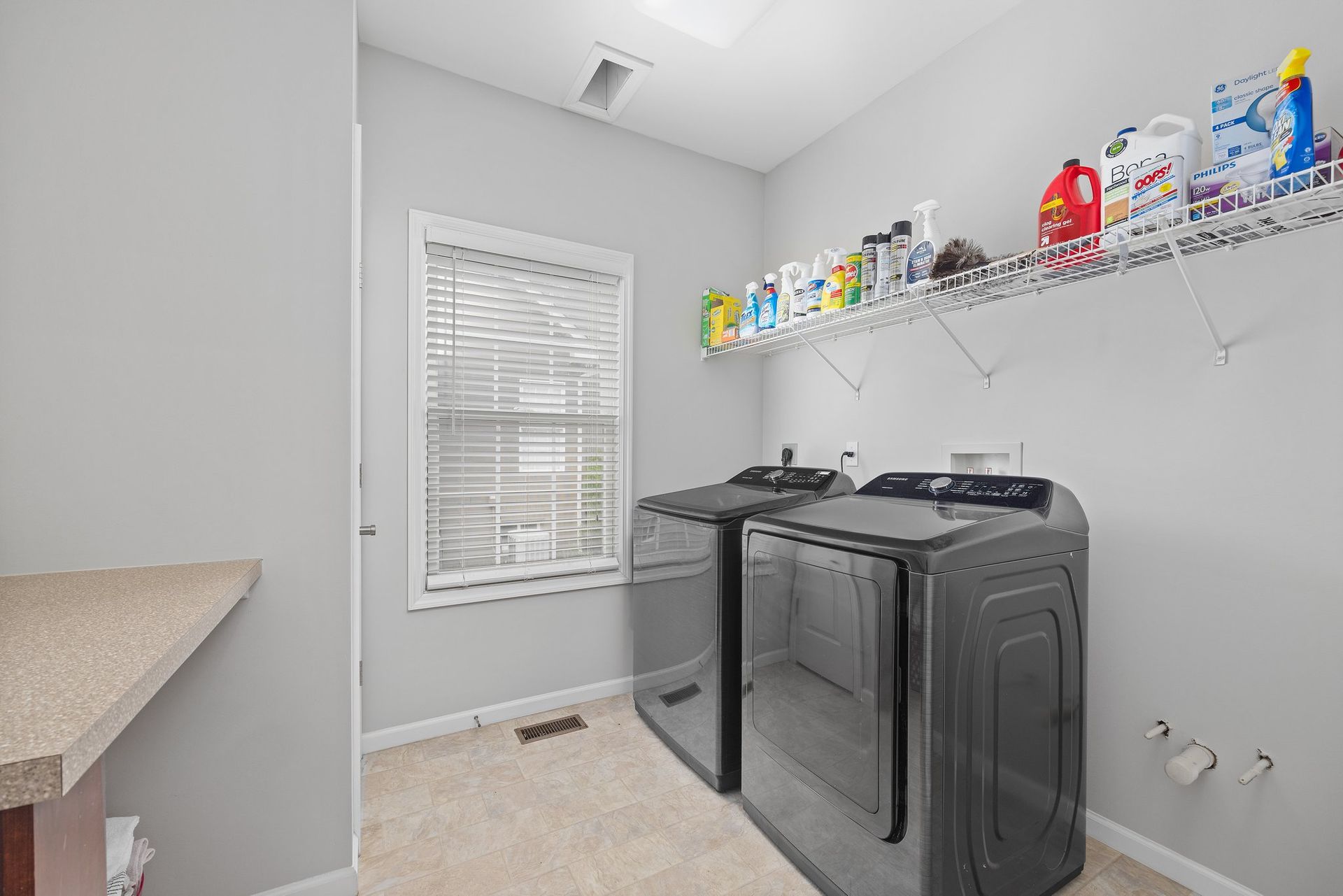 A laundry room with a washer and dryer and a window.