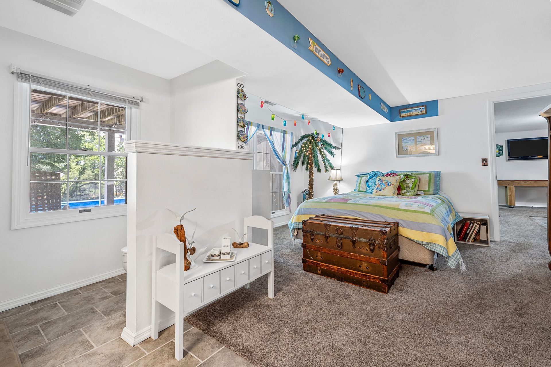 A bedroom with a bunk bed and a trunk in it.