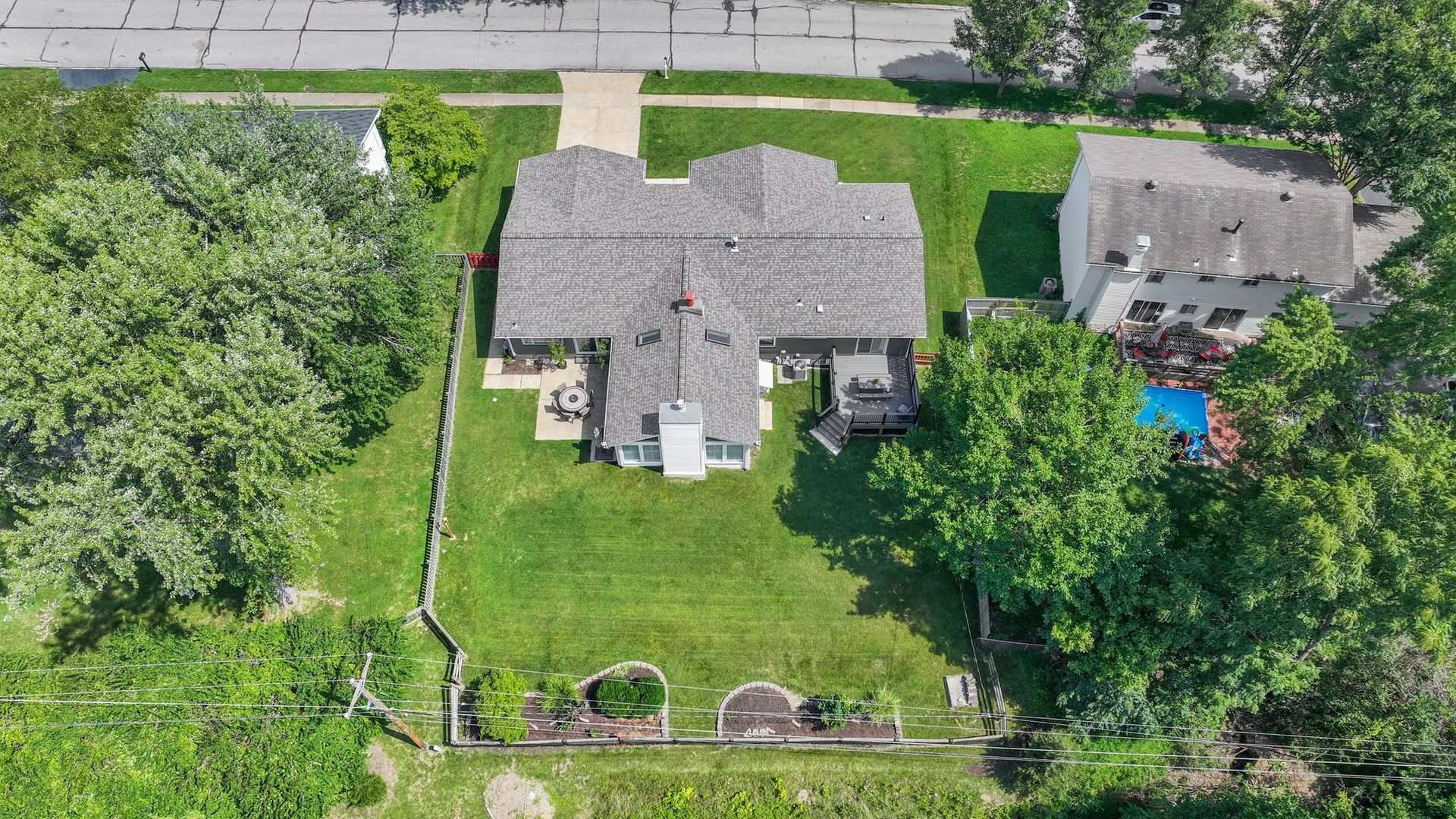 An aerial view of a house surrounded by trees and grass.