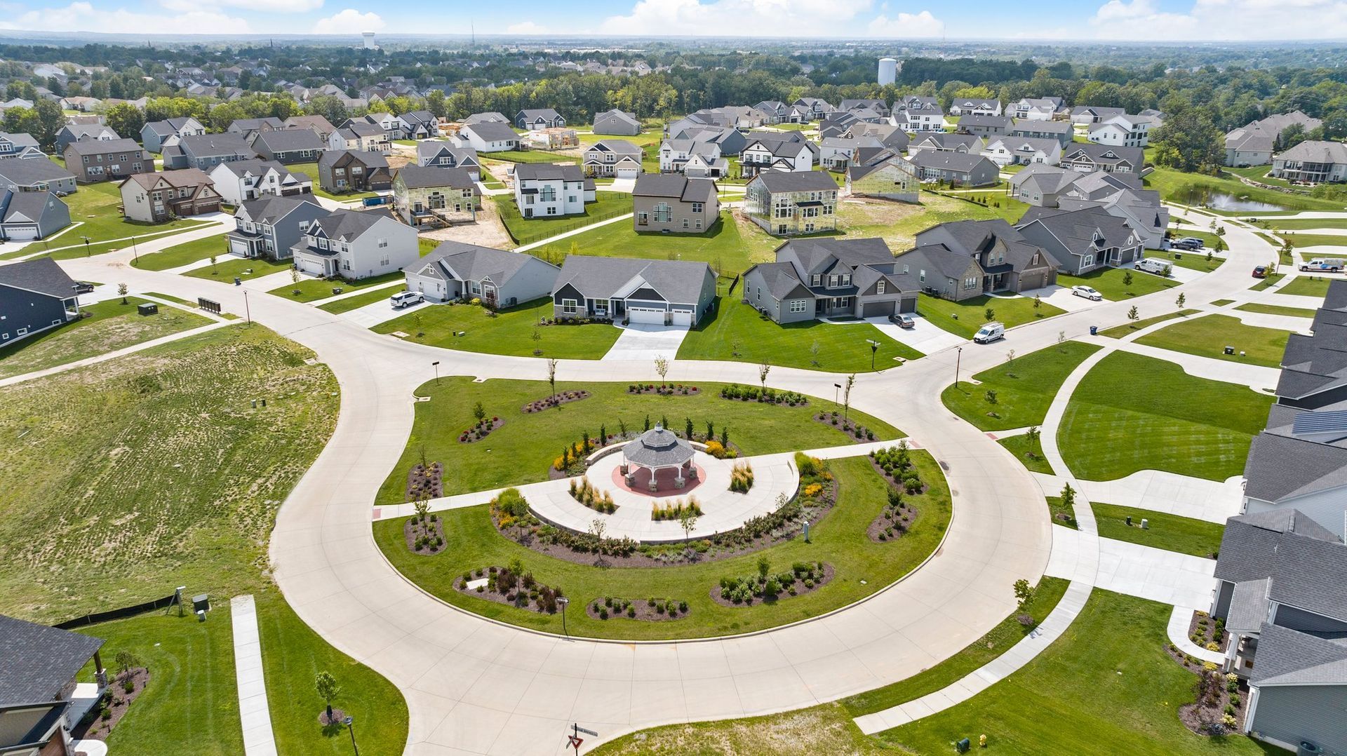 An aerial view of a residential neighborhood with a circular driveway in the middle.