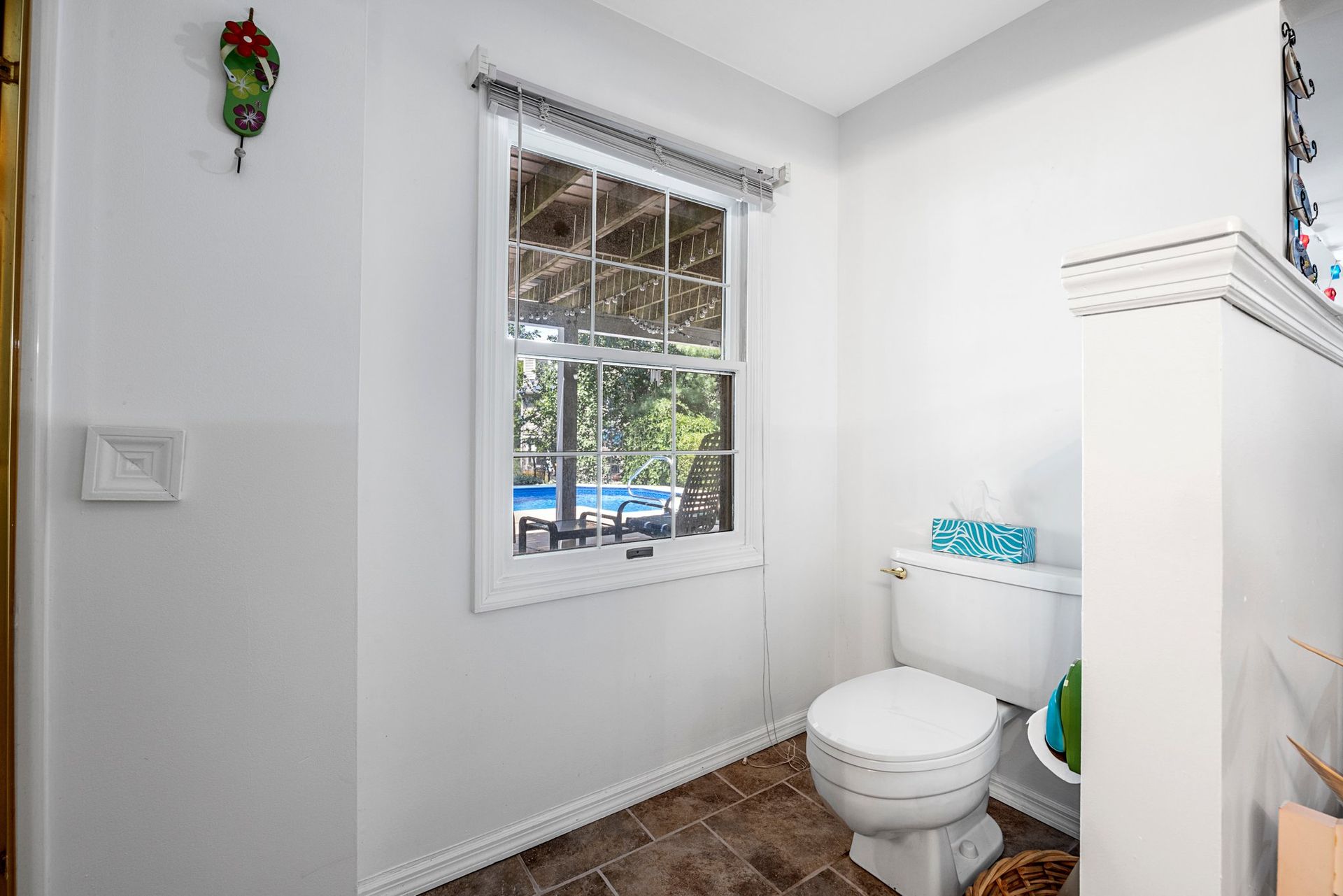 A bathroom with a toilet and a window.