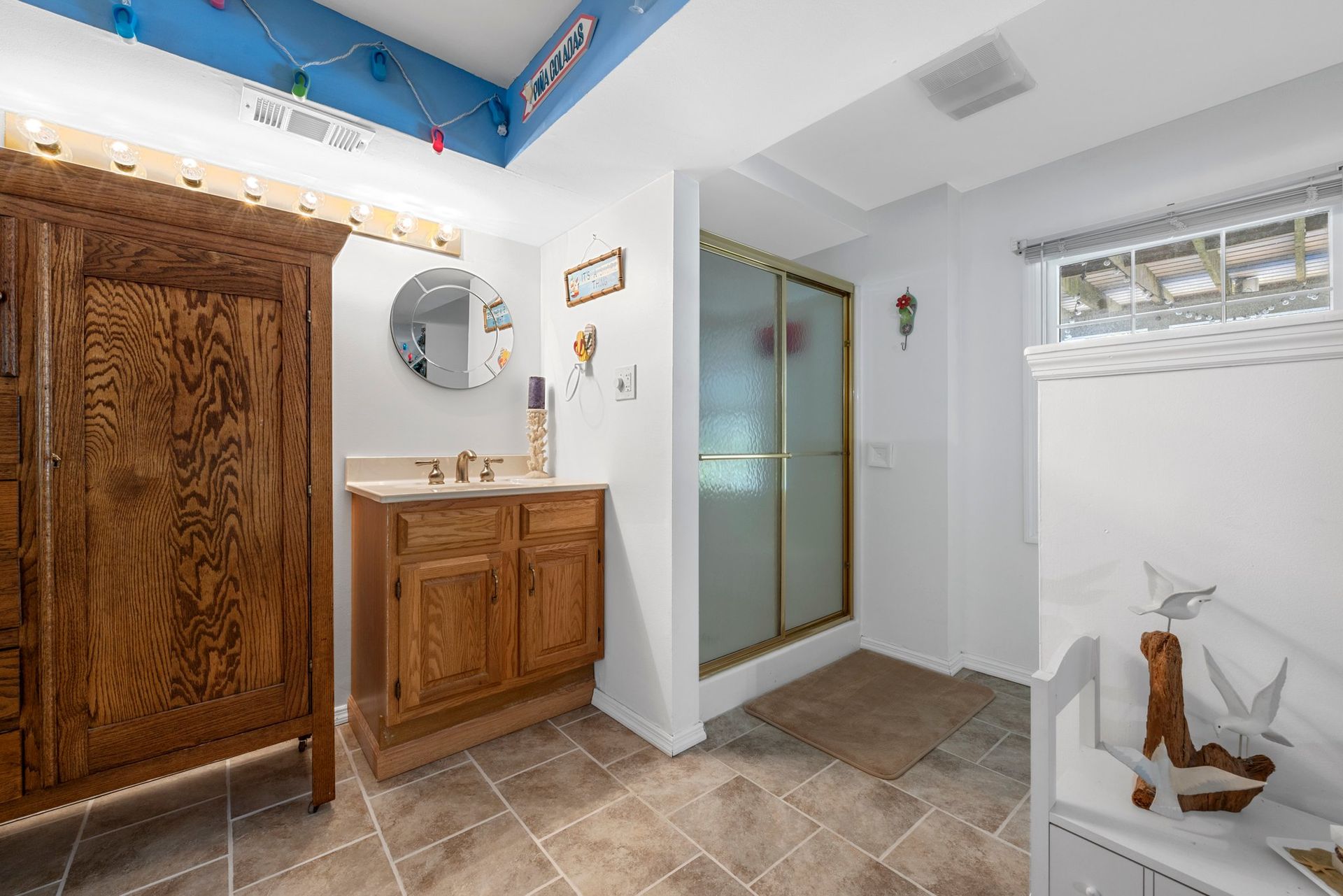 A bathroom with a sink and a walk in shower.