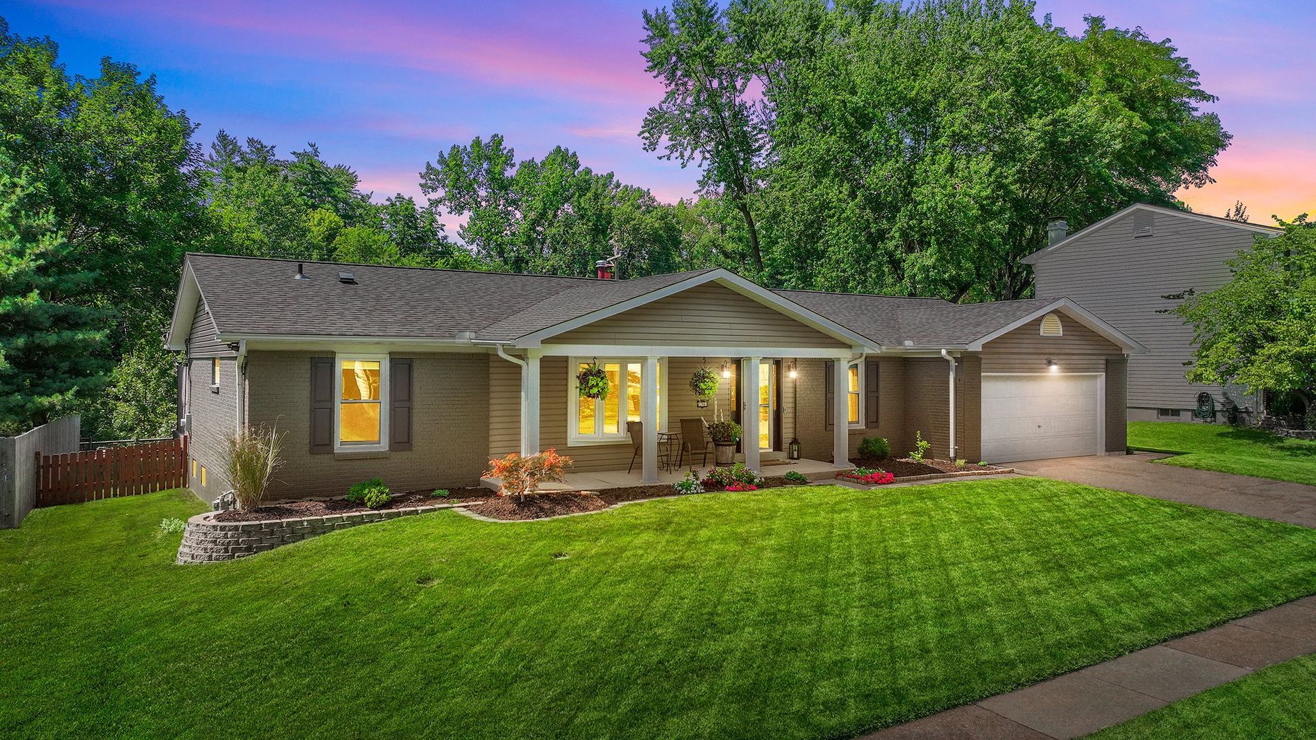 A house with a large lawn and a porch is for sale.