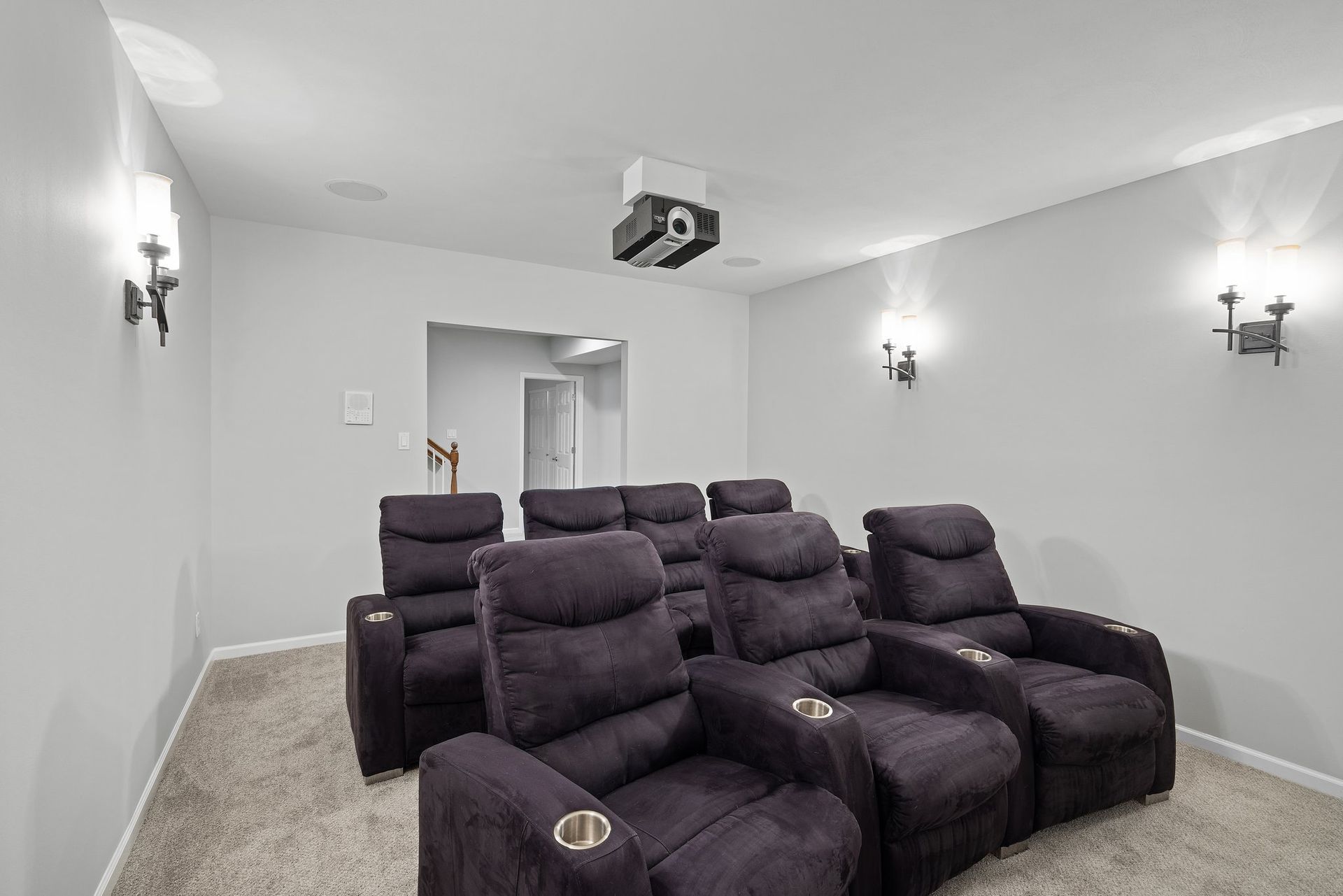 A home theater with purple chairs and a projector.