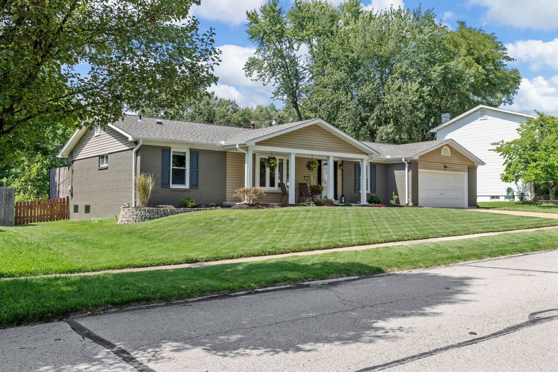 A house with a large lawn and a garage is for sale.