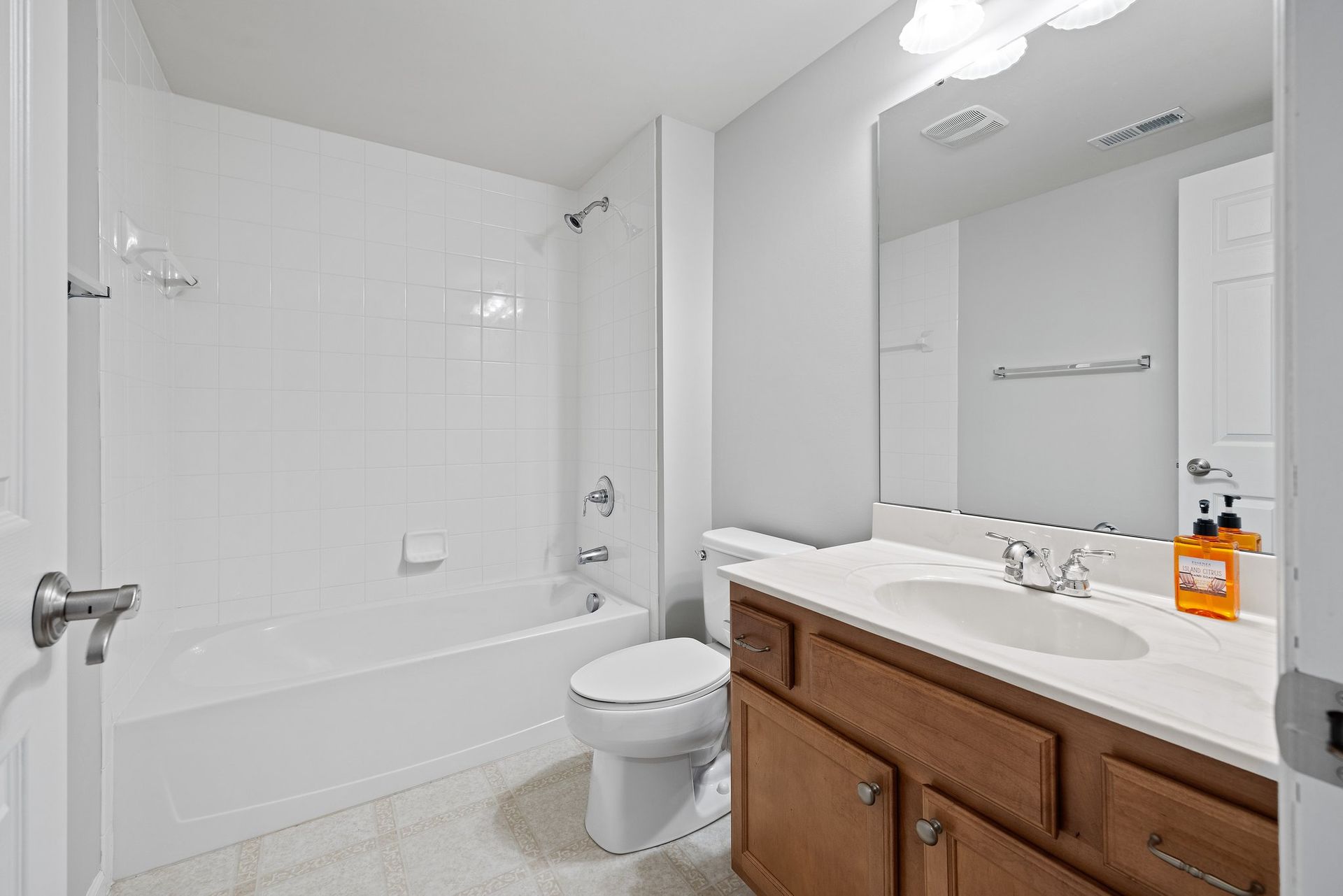 A bathroom with a toilet , sink , bathtub and mirror.