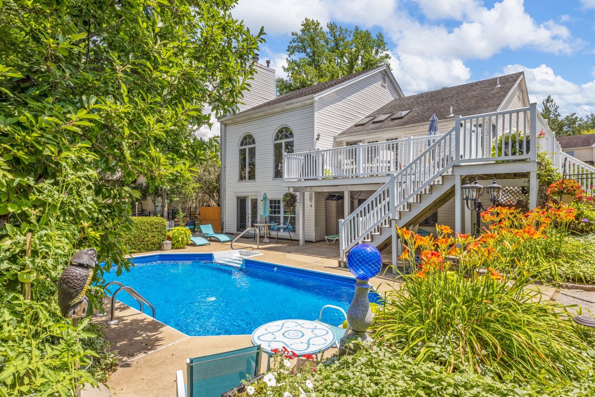 There is a large swimming pool in the backyard of a house.