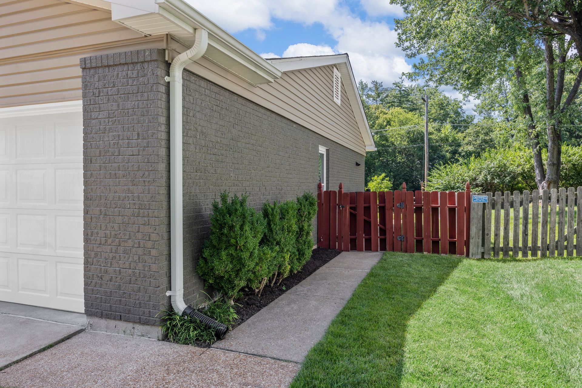 A house with a red fence and a walkway leading to it.