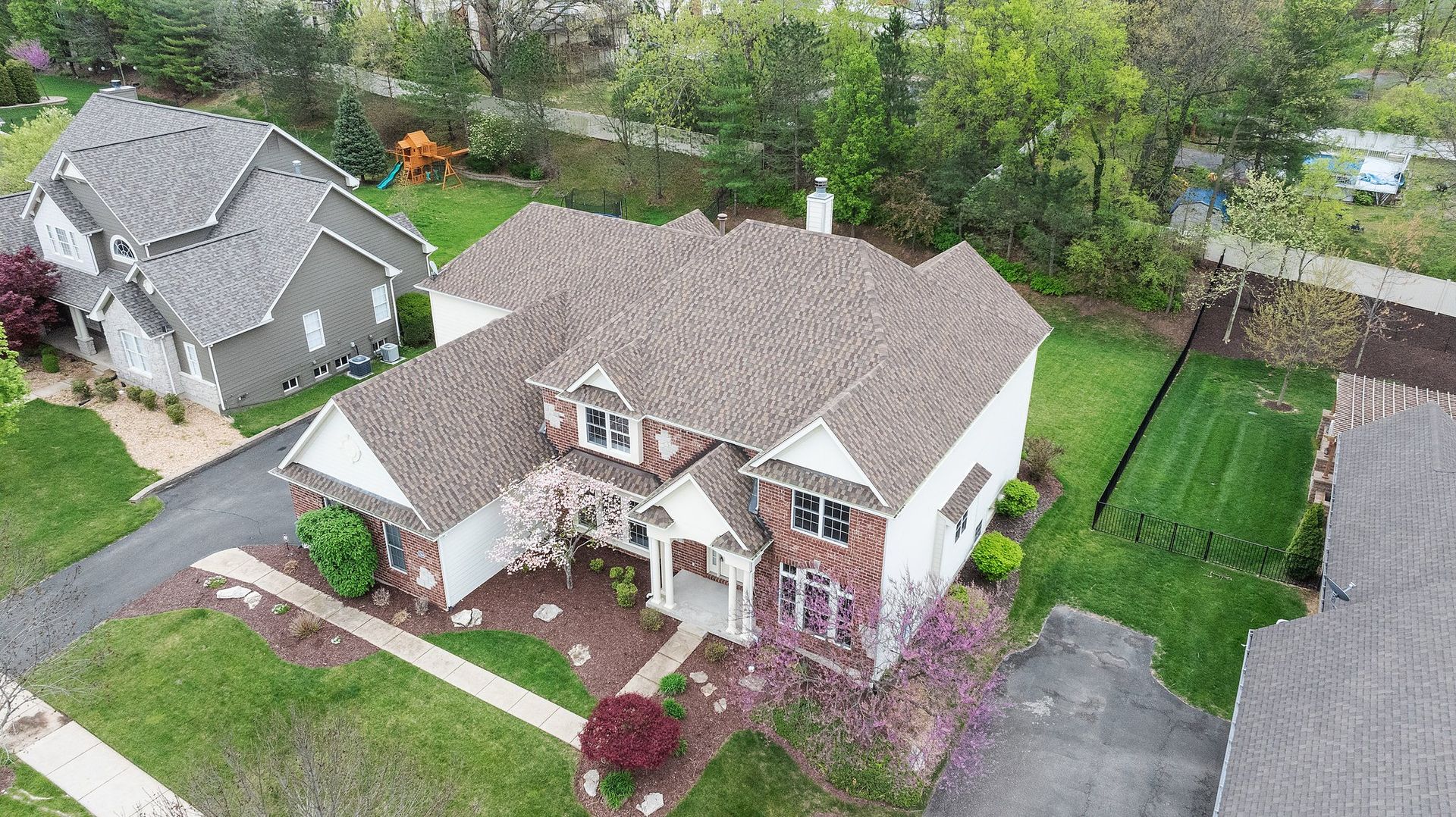 An aerial view of a large house in a residential neighborhood.