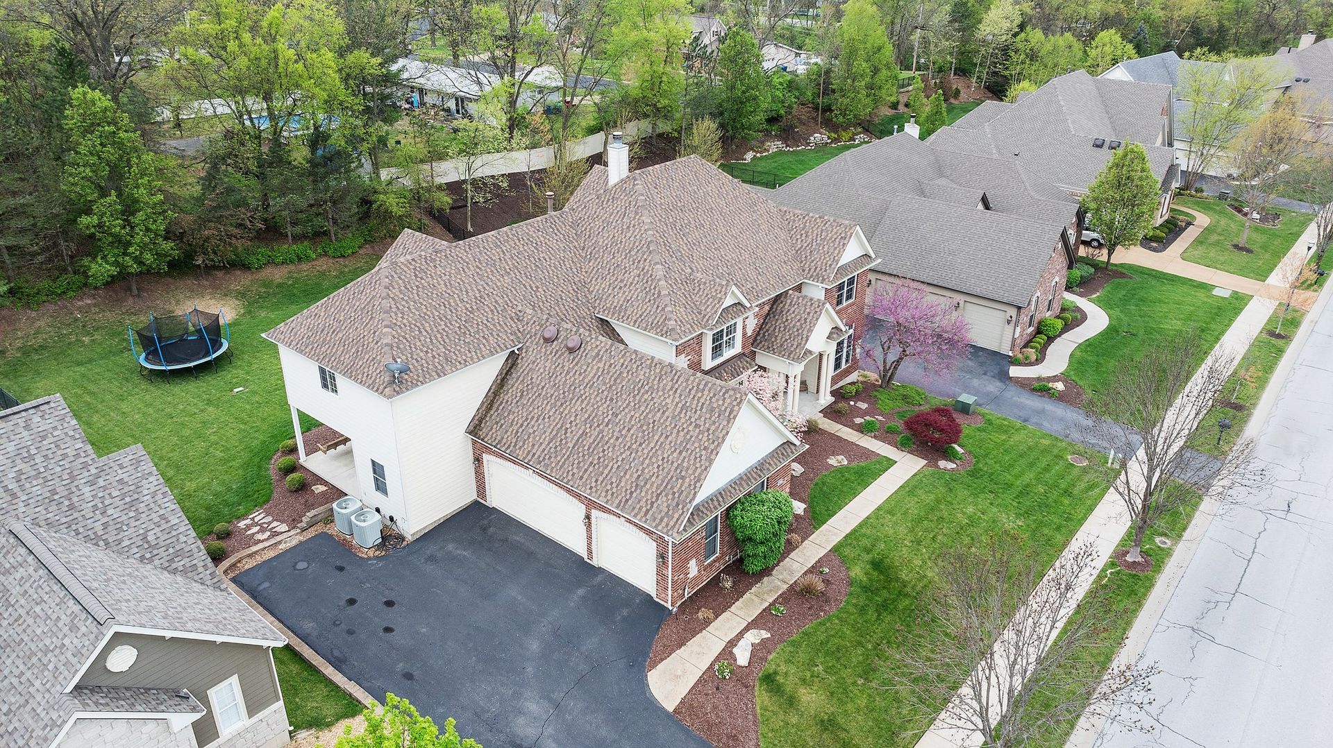 An aerial view of a residential neighborhood with a large house in the middle.