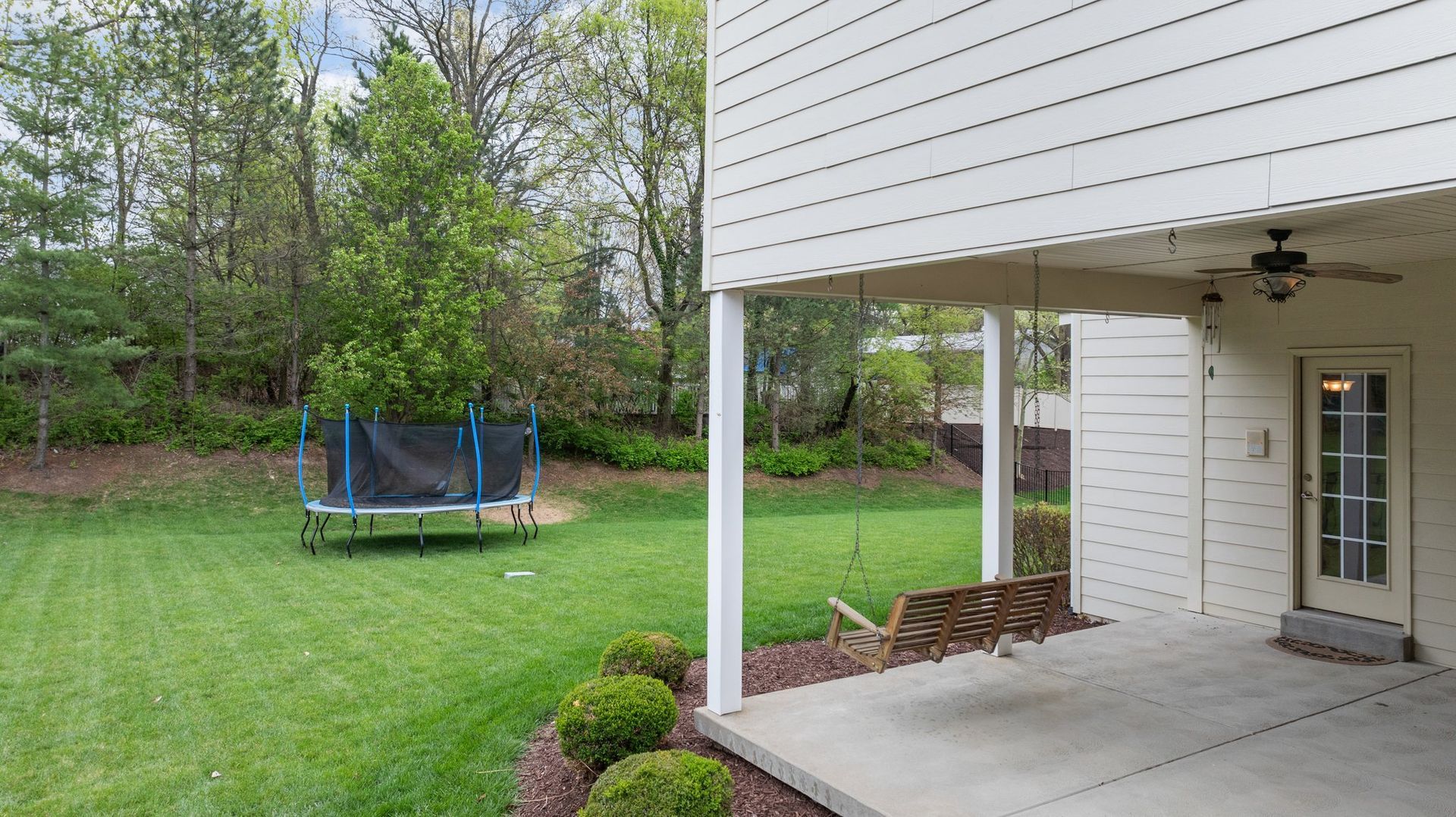 There is a trampoline in the backyard of a house.