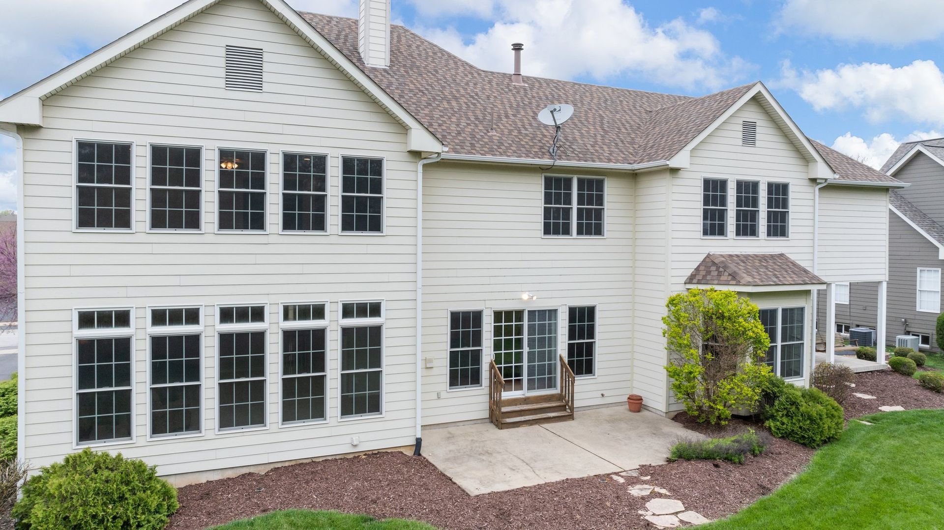 A large white house with a lot of windows and a patio.