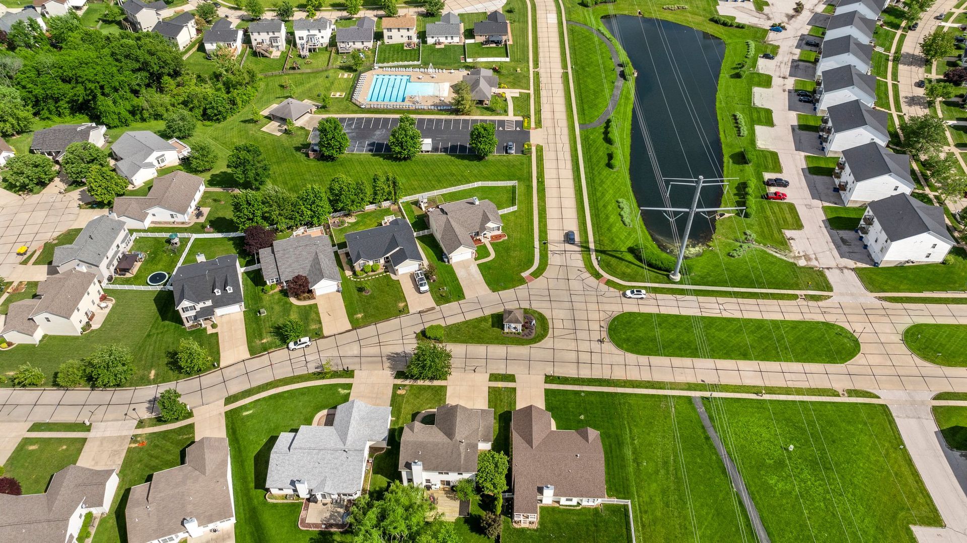 An aerial view of a residential area with a lake in the middle