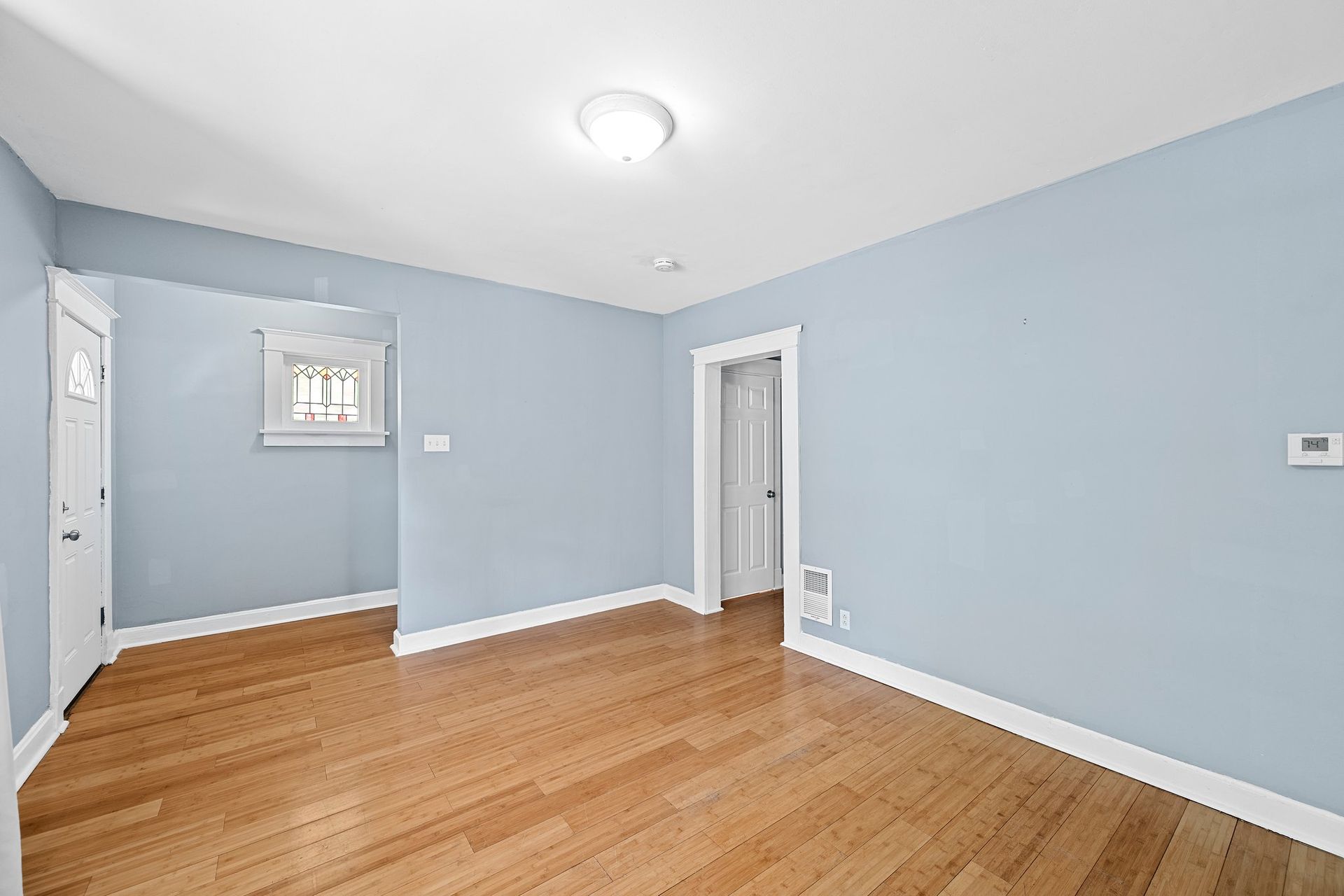 An empty room with hardwood floors and blue walls.