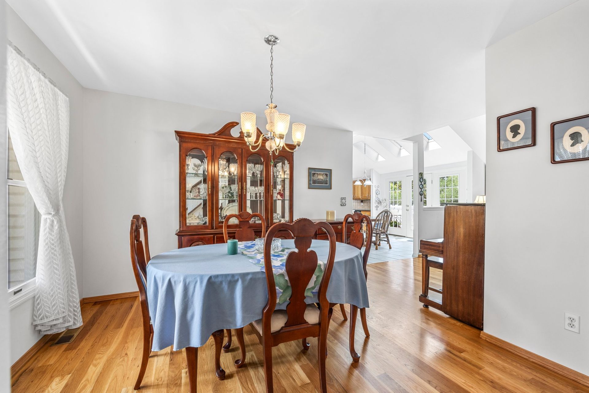 A dining room with a table and chairs and a chandelier.