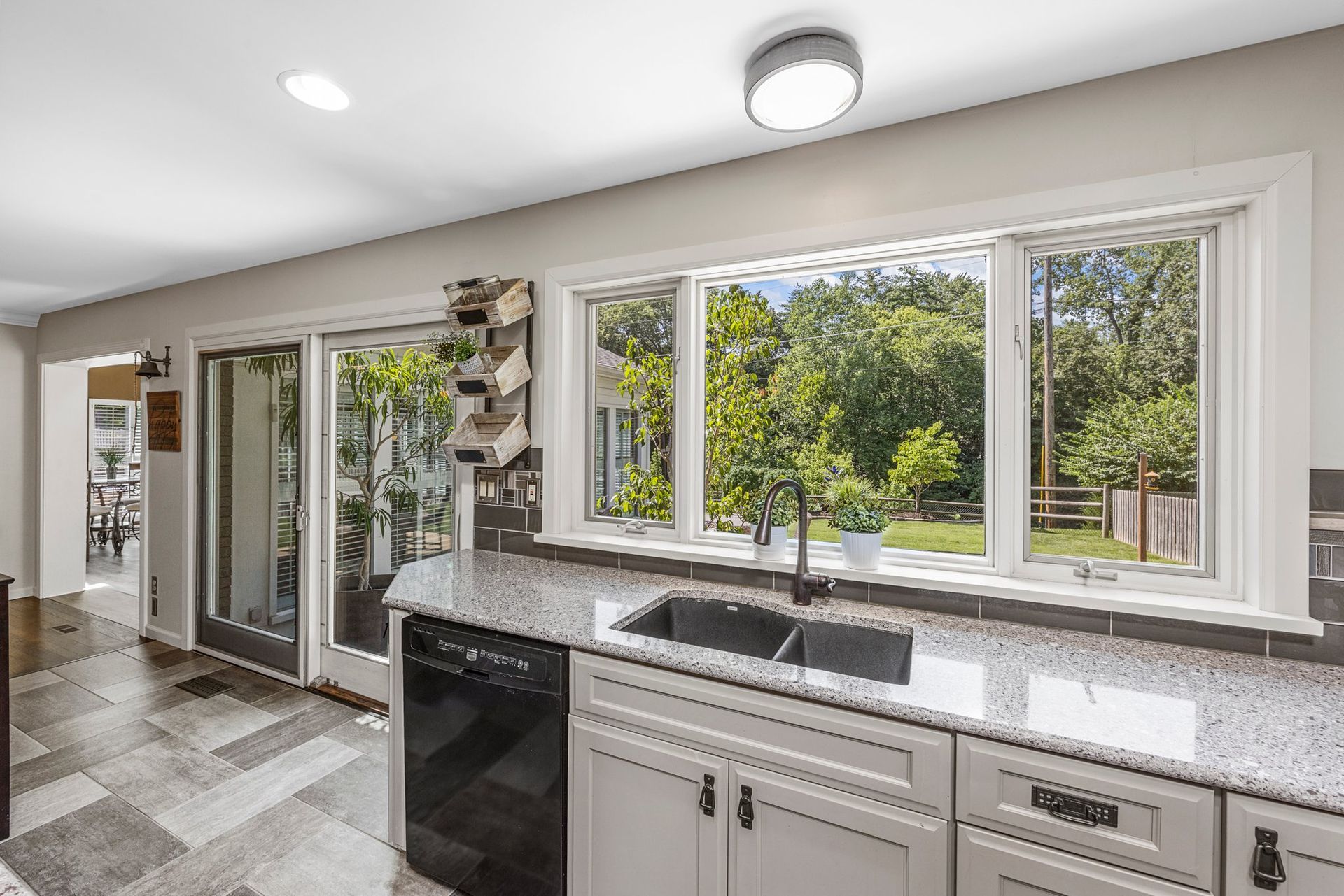 A kitchen with a sink , dishwasher , and sliding glass doors.