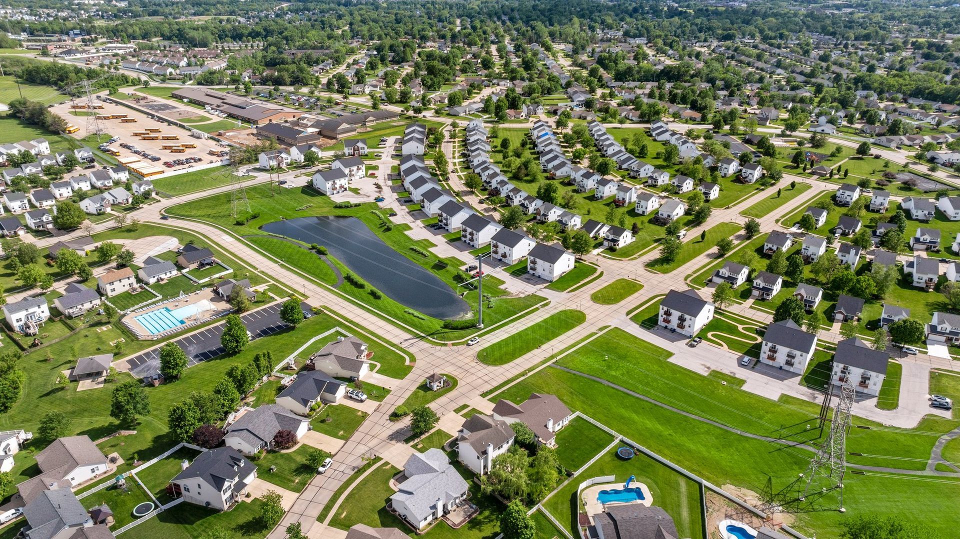 An aerial view of a residential area with lots of houses and a pond.