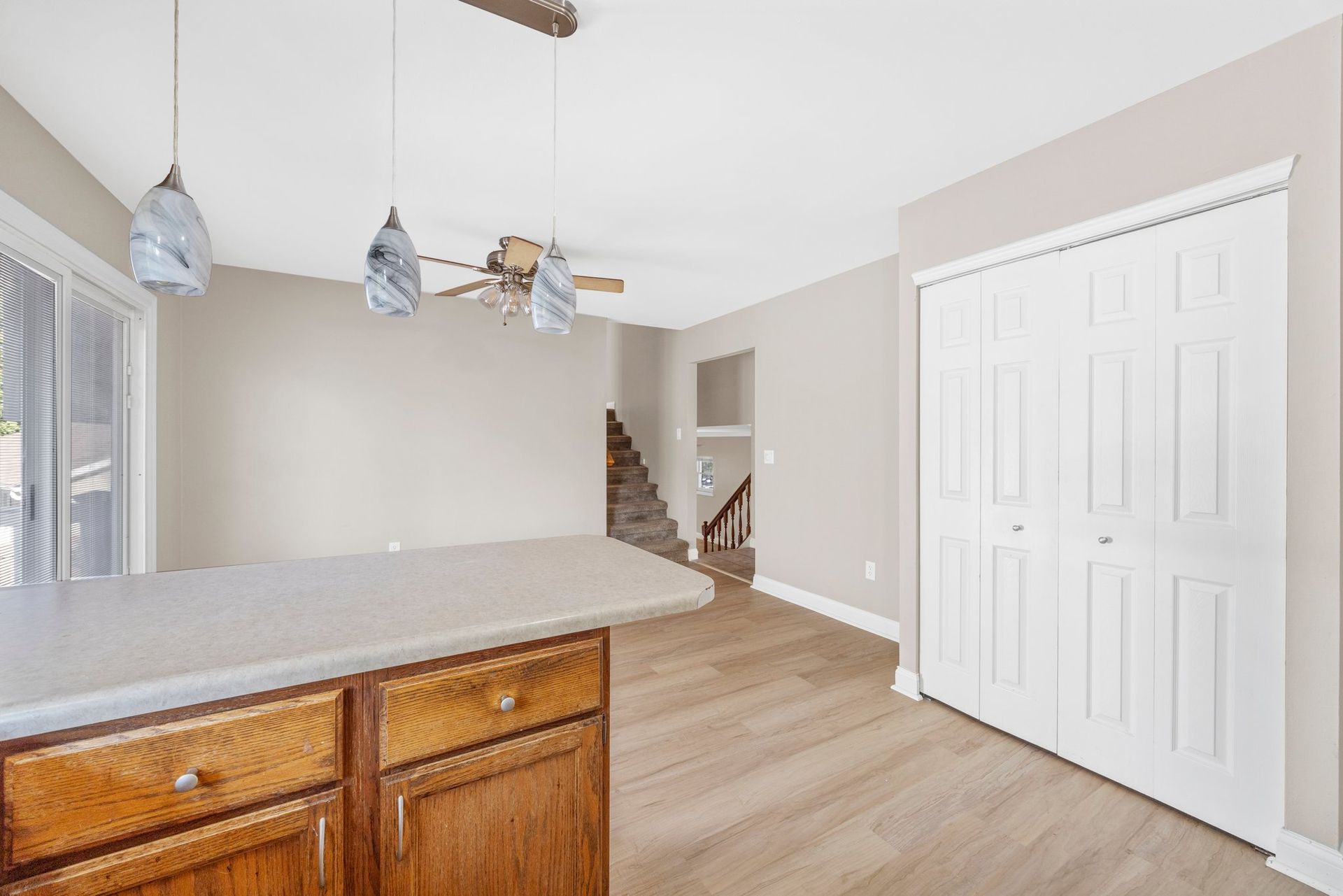 A kitchen with wooden cabinets and a ceiling fan.