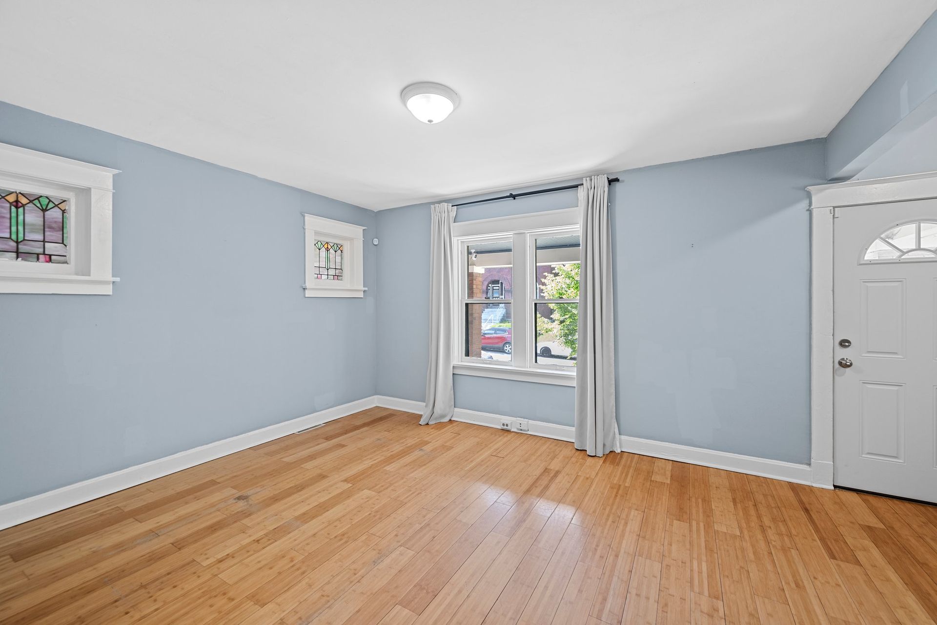 An empty living room with hardwood floors and blue walls.
