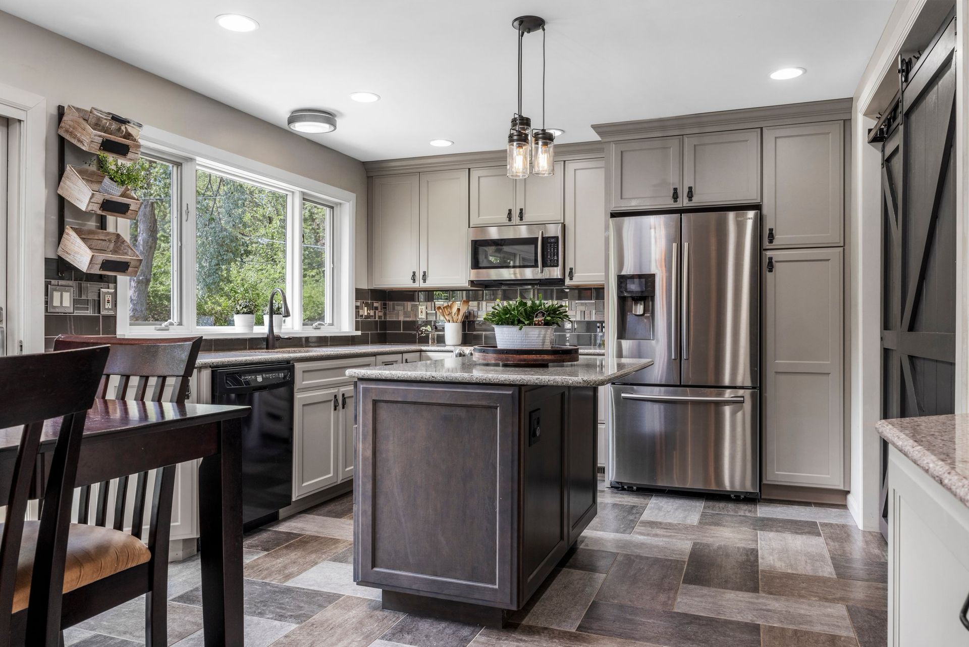 A kitchen with stainless steel appliances and a large island in the middle.
