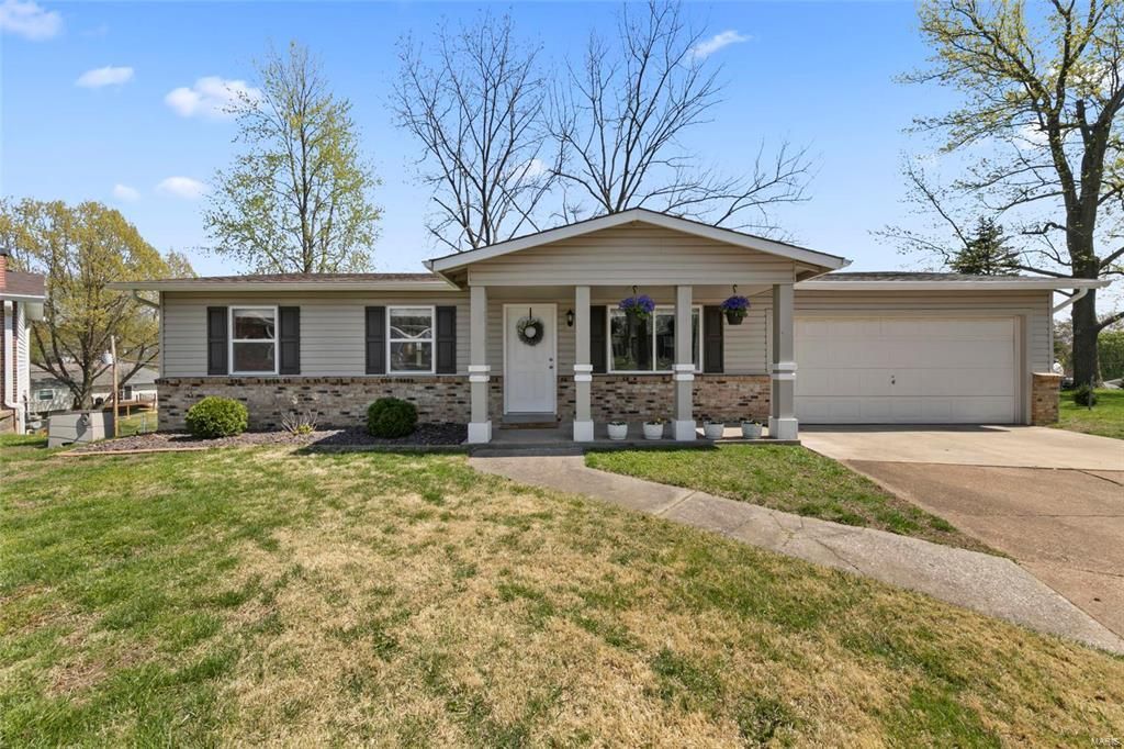 A house with a porch and a garage is for sale.
