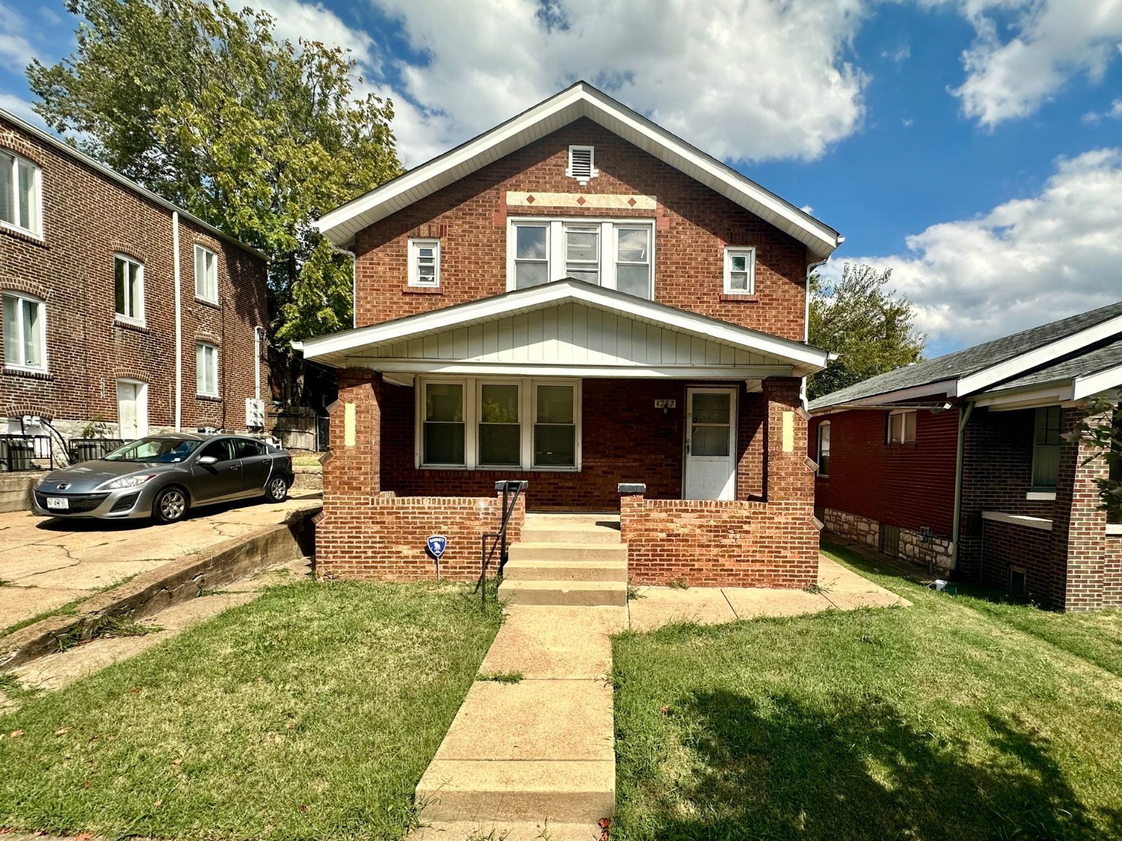 A brick house with a car parked in front of it.