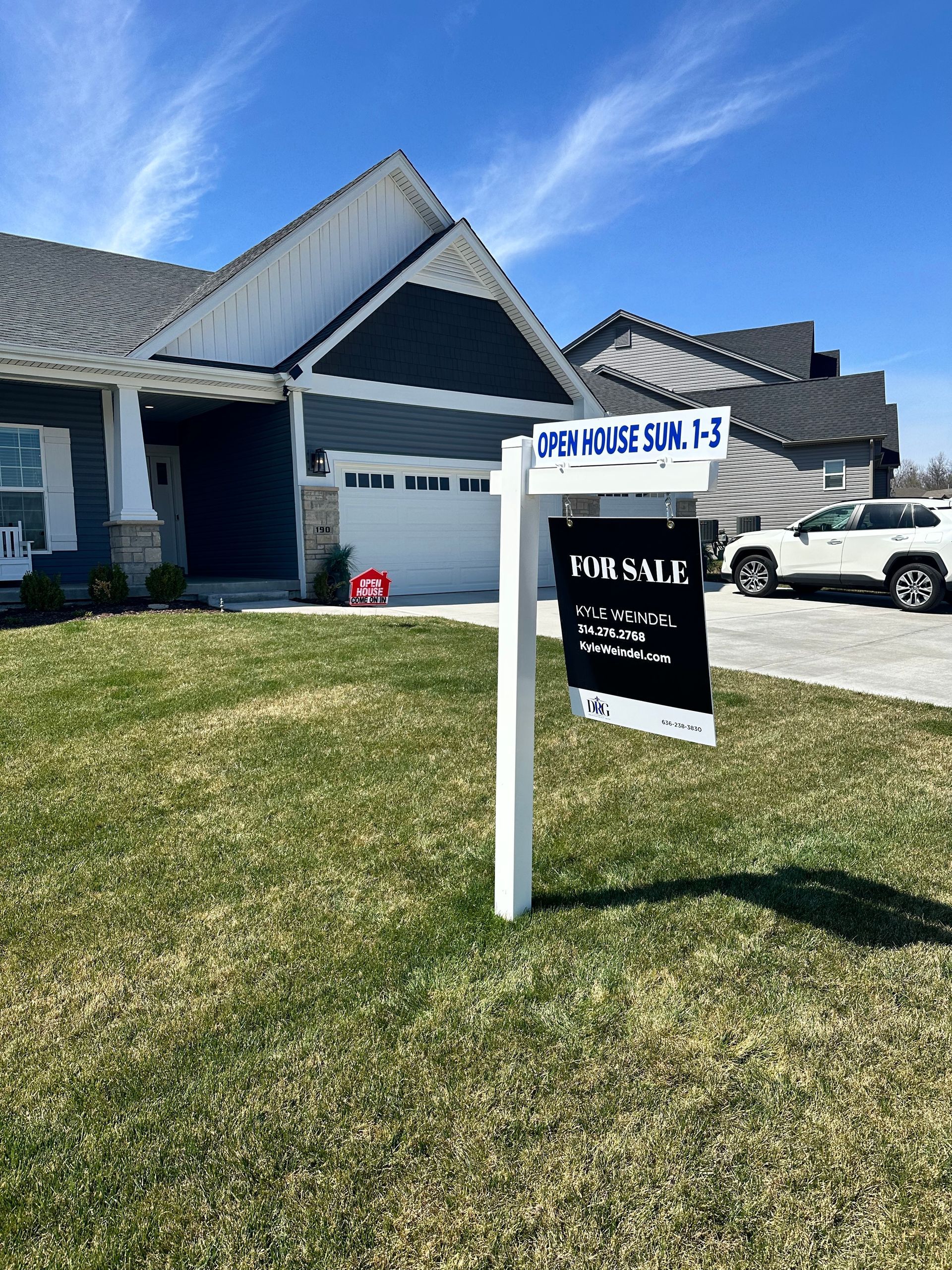 A house with a for sale sign in front of it.