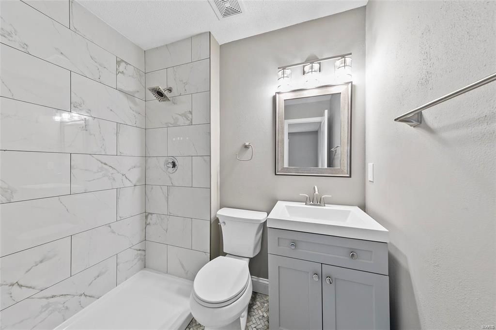 A bathroom with a toilet , sink , and shower.