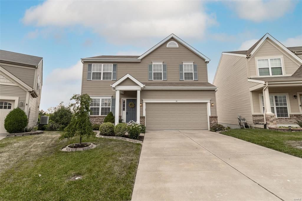A large house with a garage and a driveway in front of it