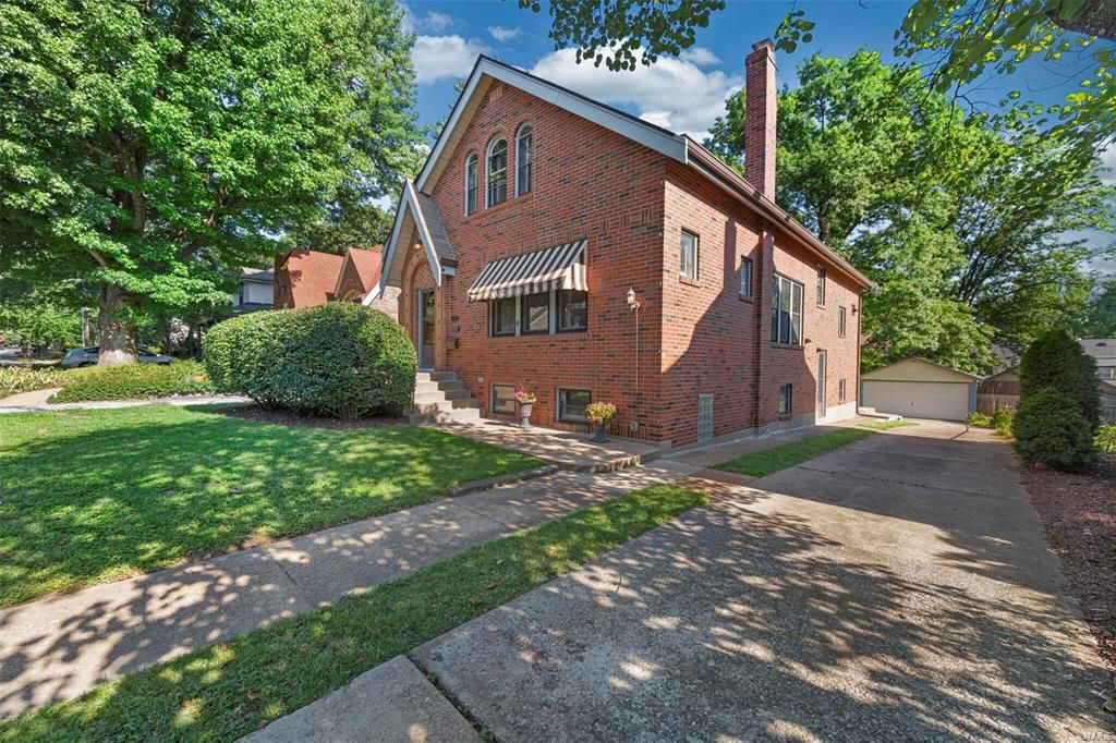 A large brick house with a lot of windows is for sale.