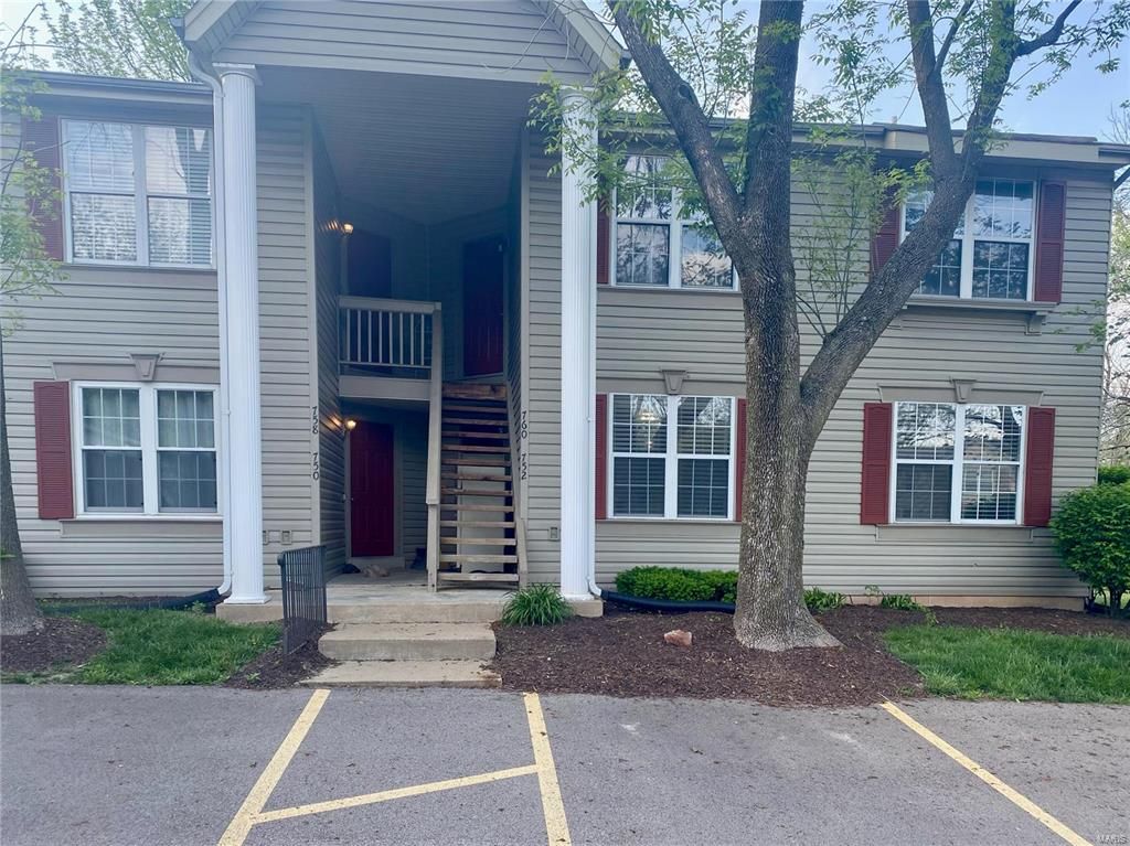 A large apartment building with a tree in front of it