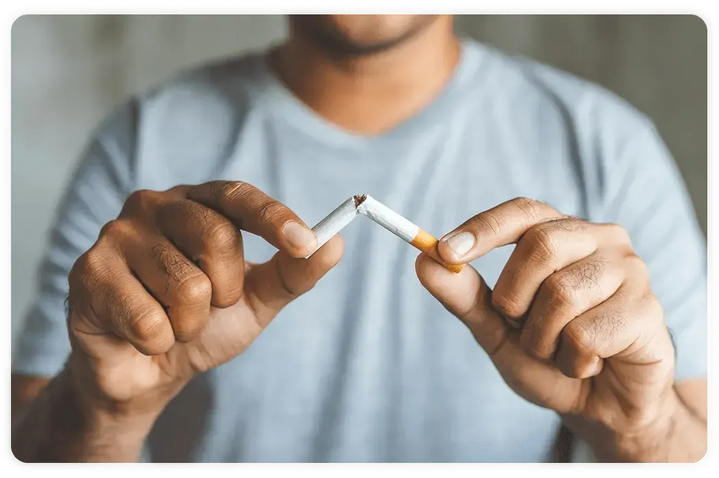 a man breaking a cigarette in half