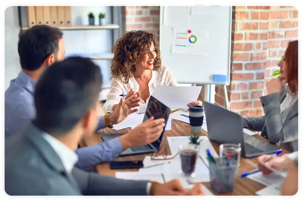 A group of people are sitting around a table having a meeting.
