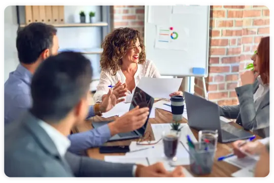 A group of people are sitting around a table having a meeting.