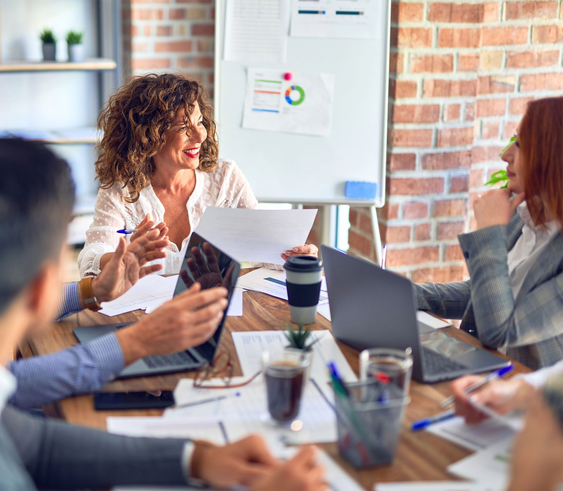 A group of people are sitting around a table having a meeting.